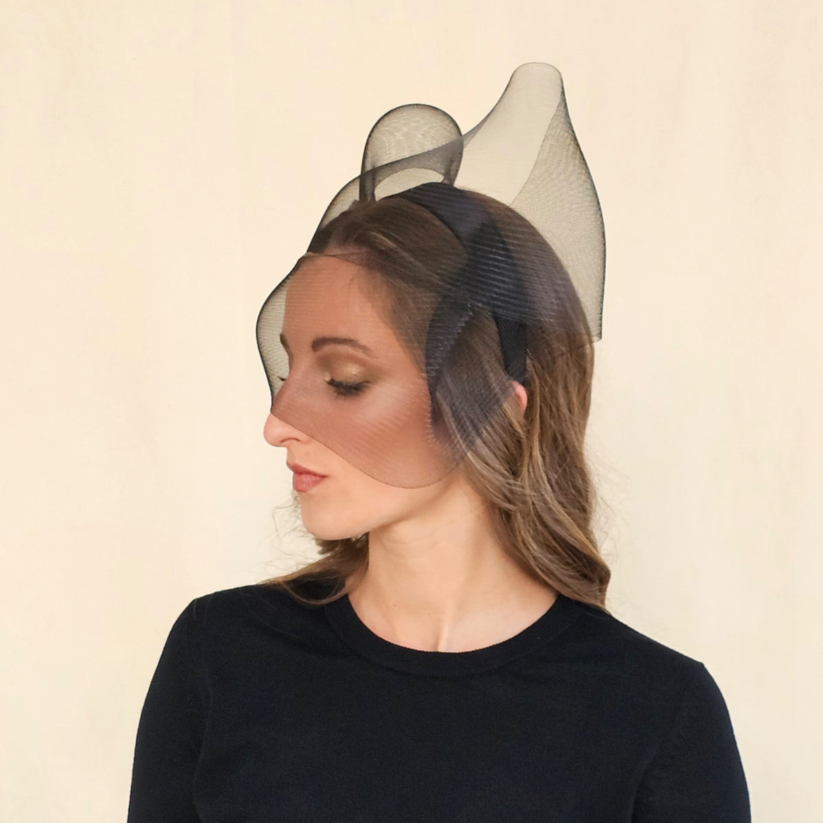 Profile of black crin bow headband showing upright loops and face
veil