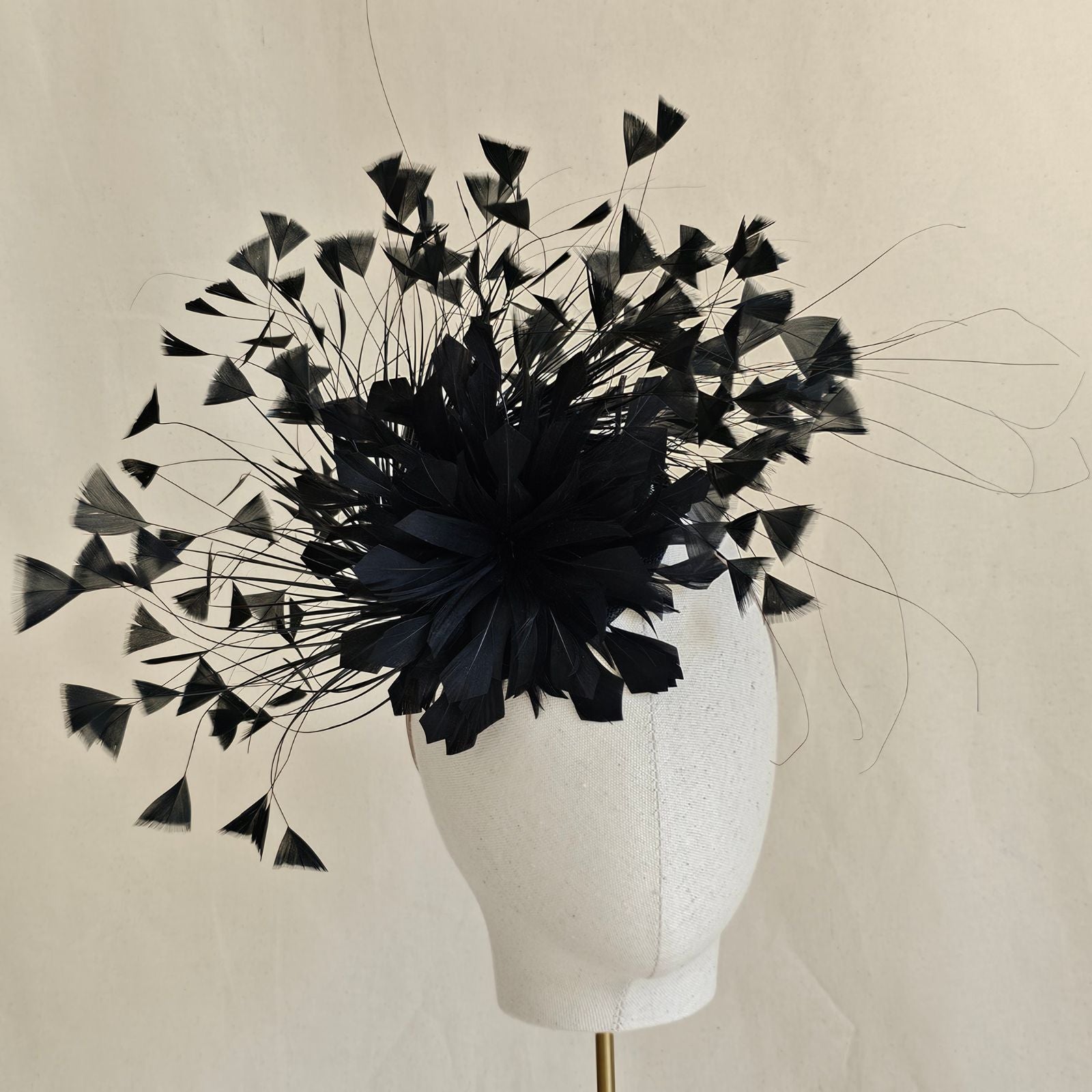 Black feather fascinator with feather flower, front view.