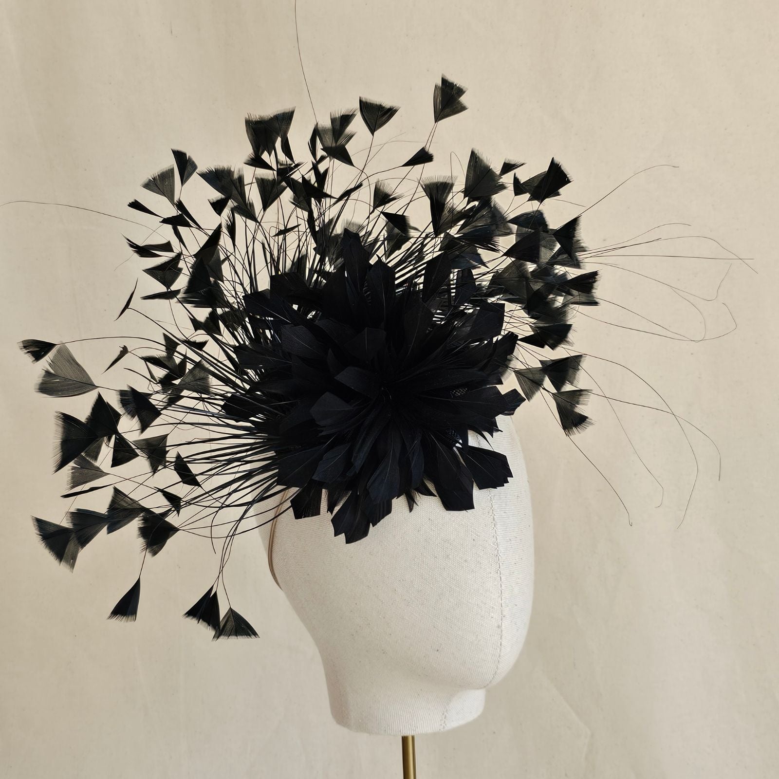Black feather fascinator with feather flower, side view.