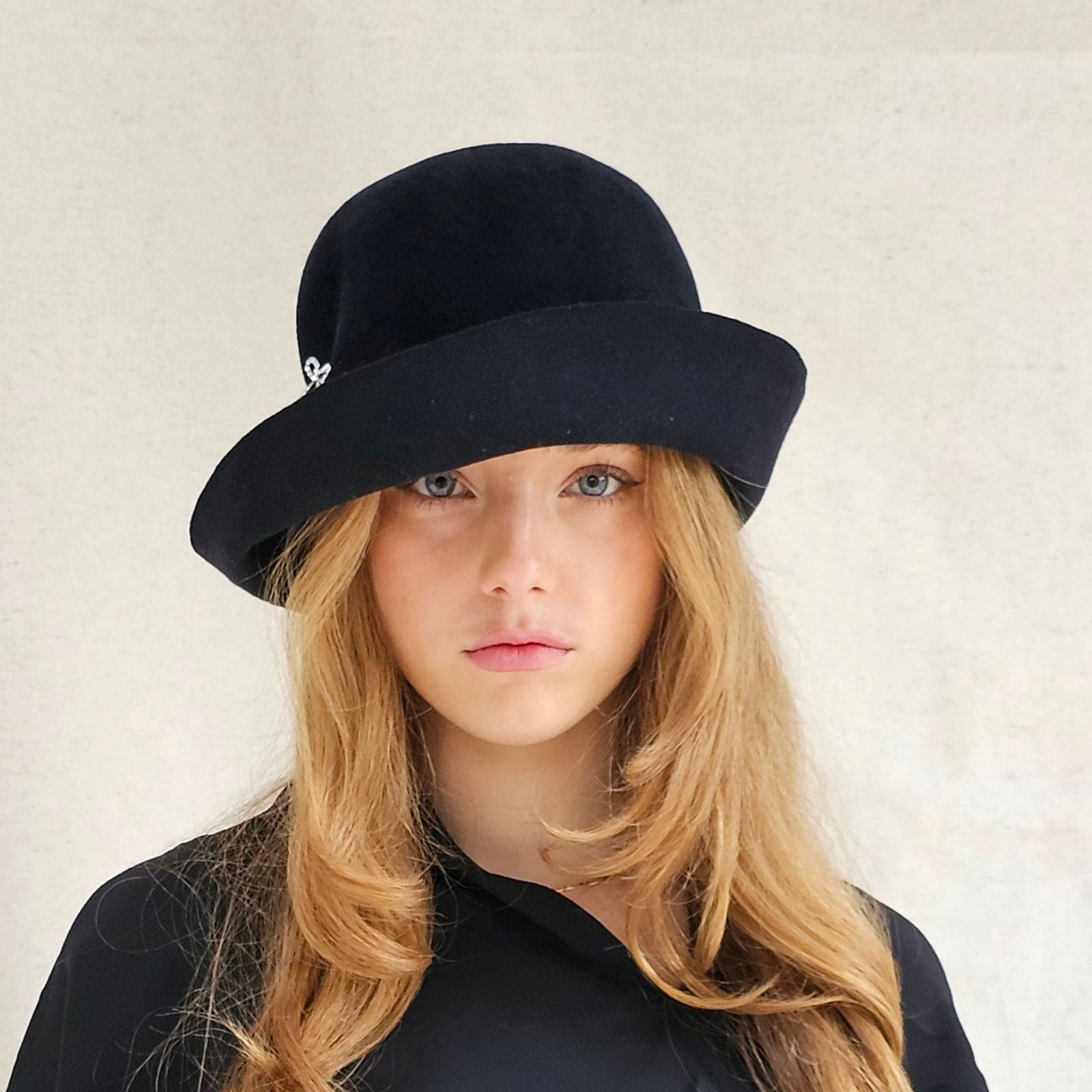 Black felt cloche hat with beautiful bow embellishment, front view.