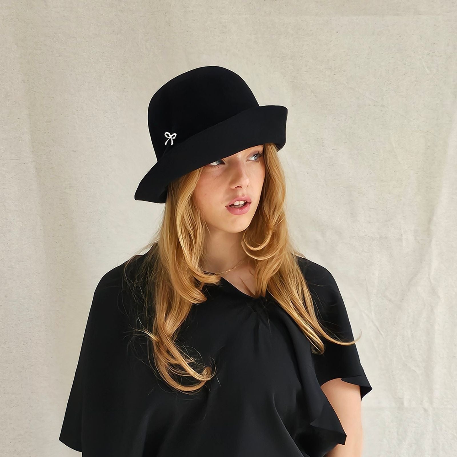 Black felt cloche hat with beautiful bow embellishment, right view.