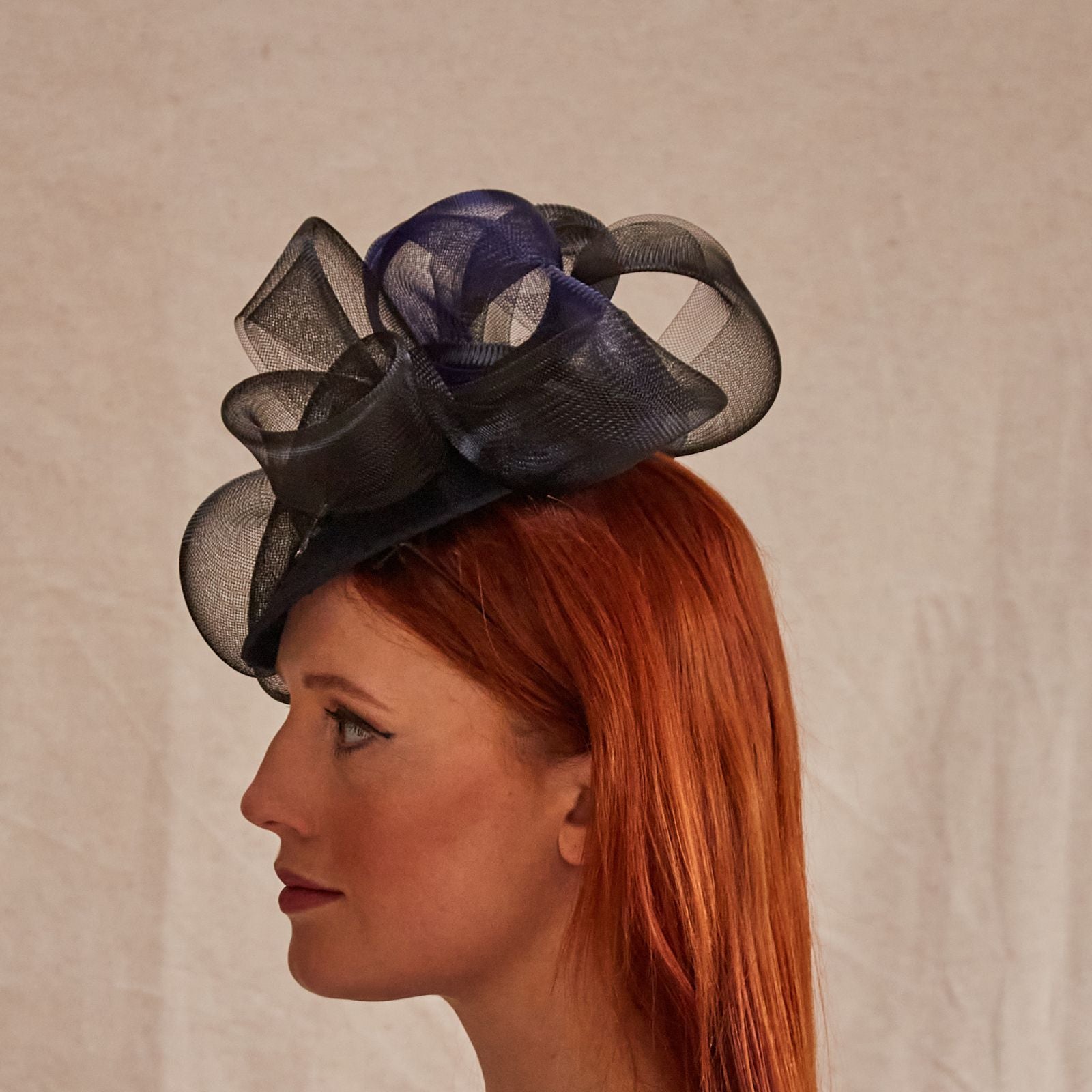 Black and navy peak fascinator with beautiful crin swirls and dragonfly embellishment, rear view.