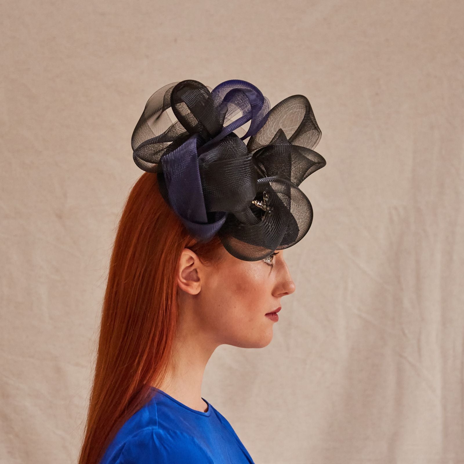 Black and navy peak fascinator with beautiful crin swirls and dragonfly embellishment, side view.