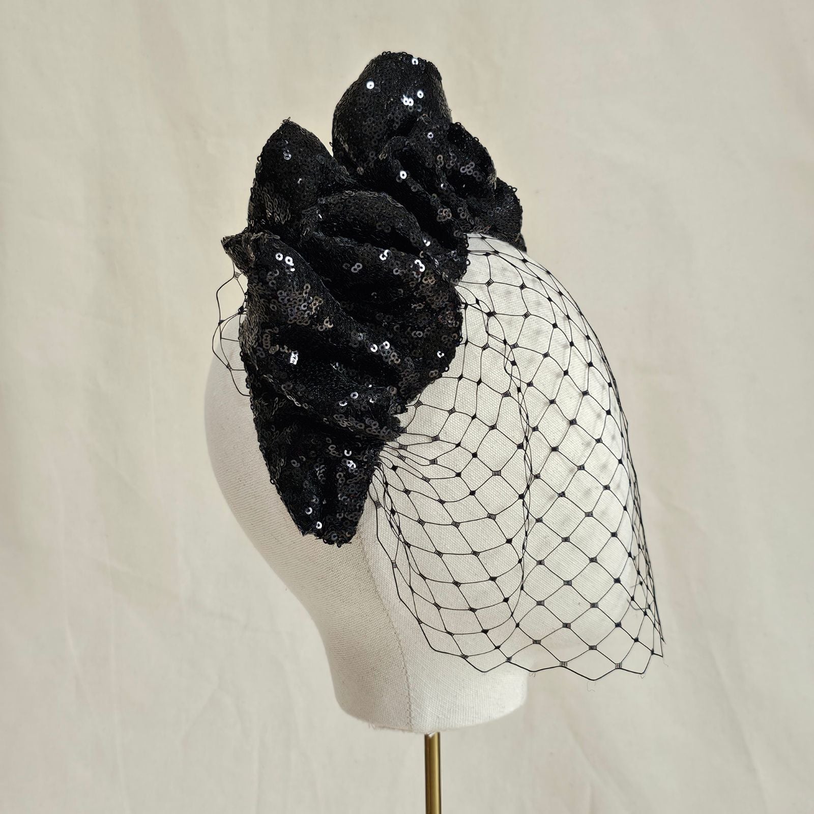 Black sequin gathered wave headband with birdcage face veil, side view.
