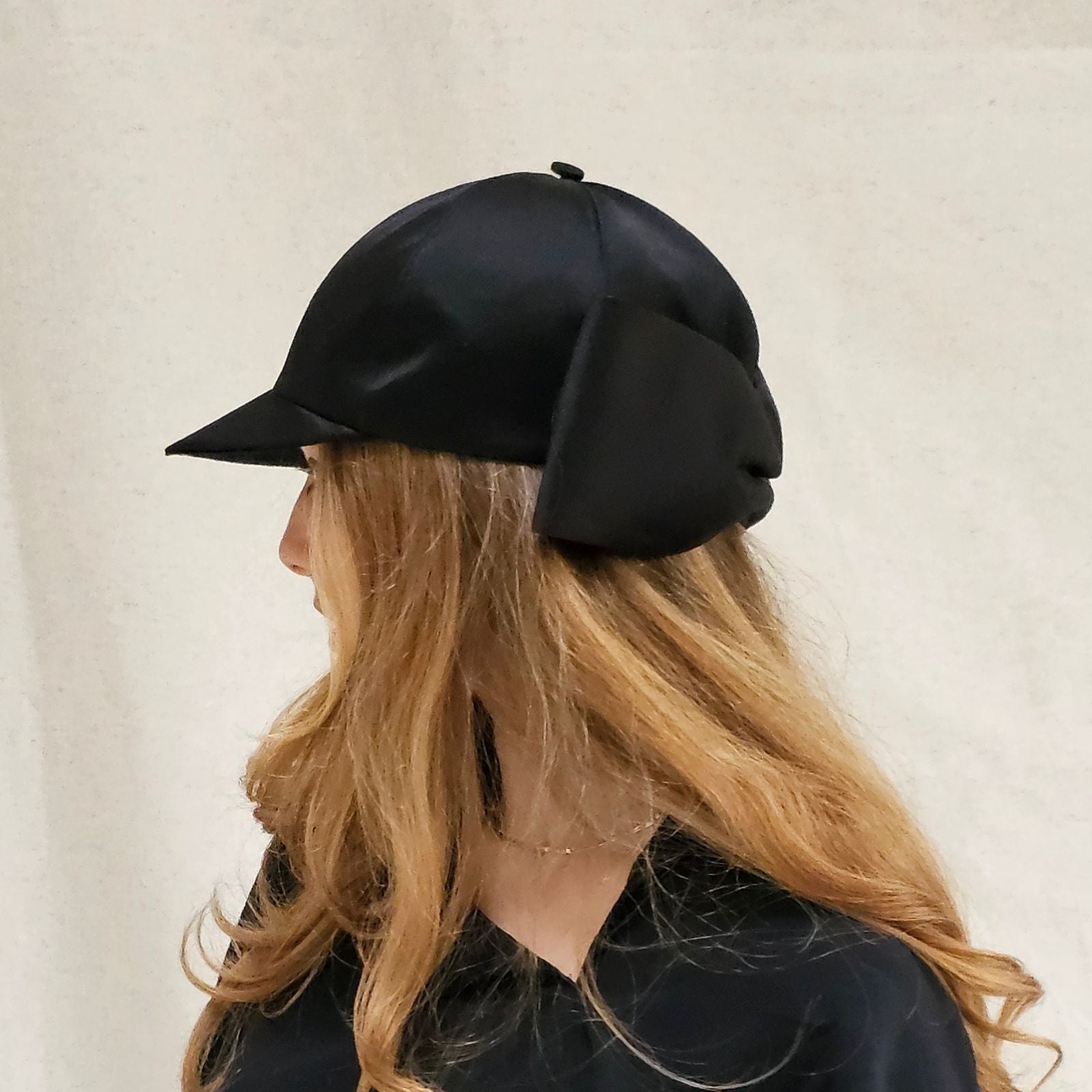 Black silk baseball cap with dramatic bow, left view.
