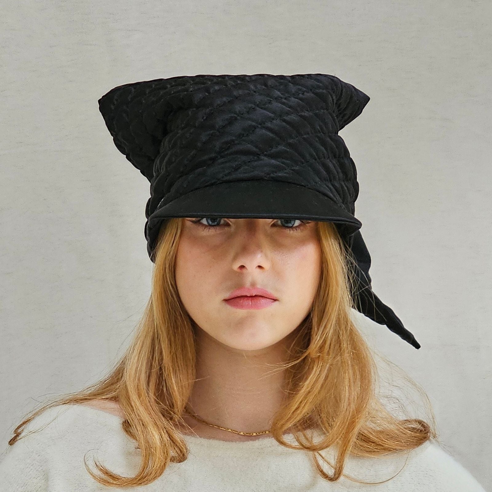 Black silk quilted peak scarf hat, front view.