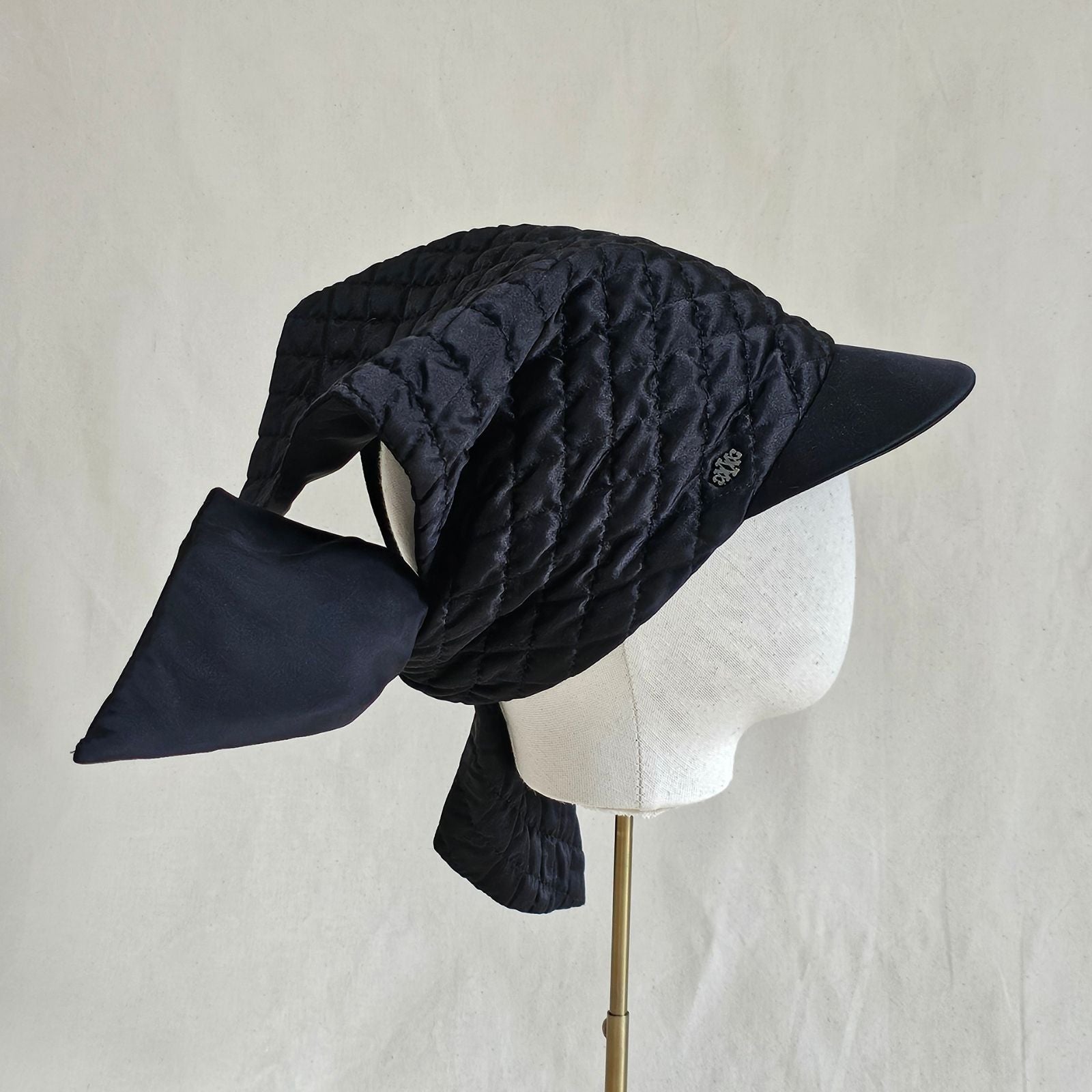 Black silk quilted peak scarf hat with dramatic back tie, right back view.