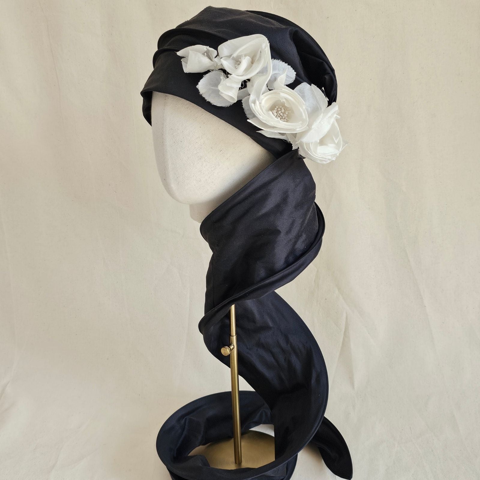 Black silk scarf turban with delicate ivory flowers, left loose view.