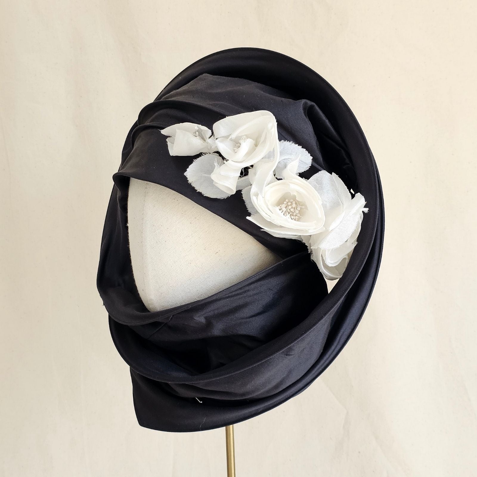 Black silk scarf turban with delicate ivory flowers, wrapped angle view.
