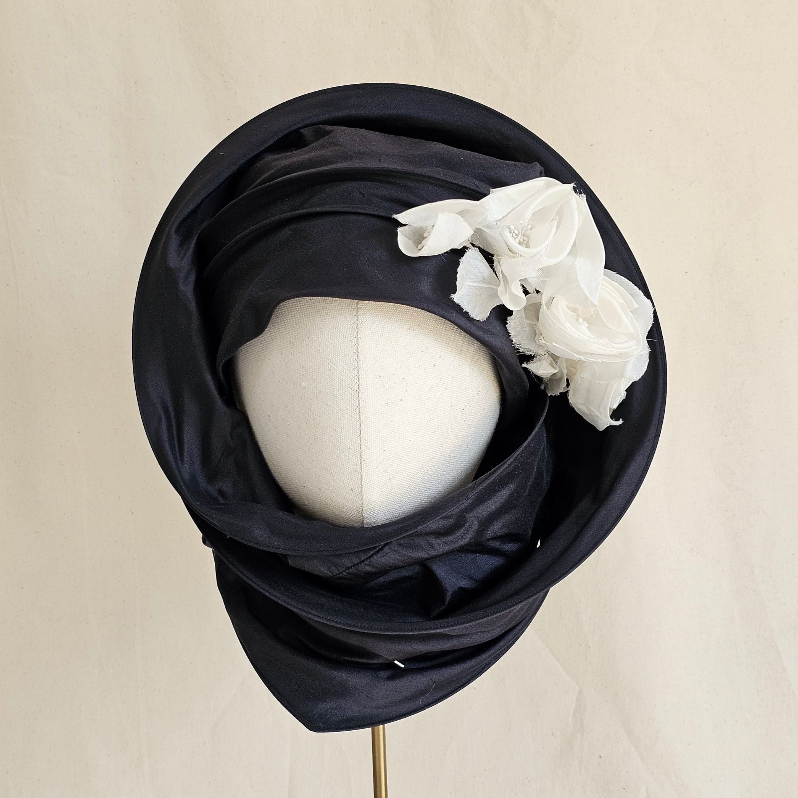 Black silk scarf turban with delicate ivory flowers, wrapped front view.