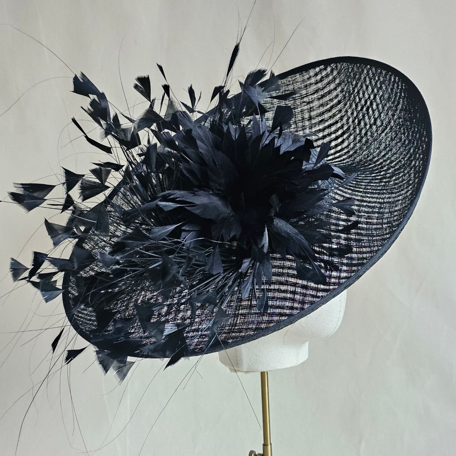 Black siname breton hat with beautiful feather flower, side view.