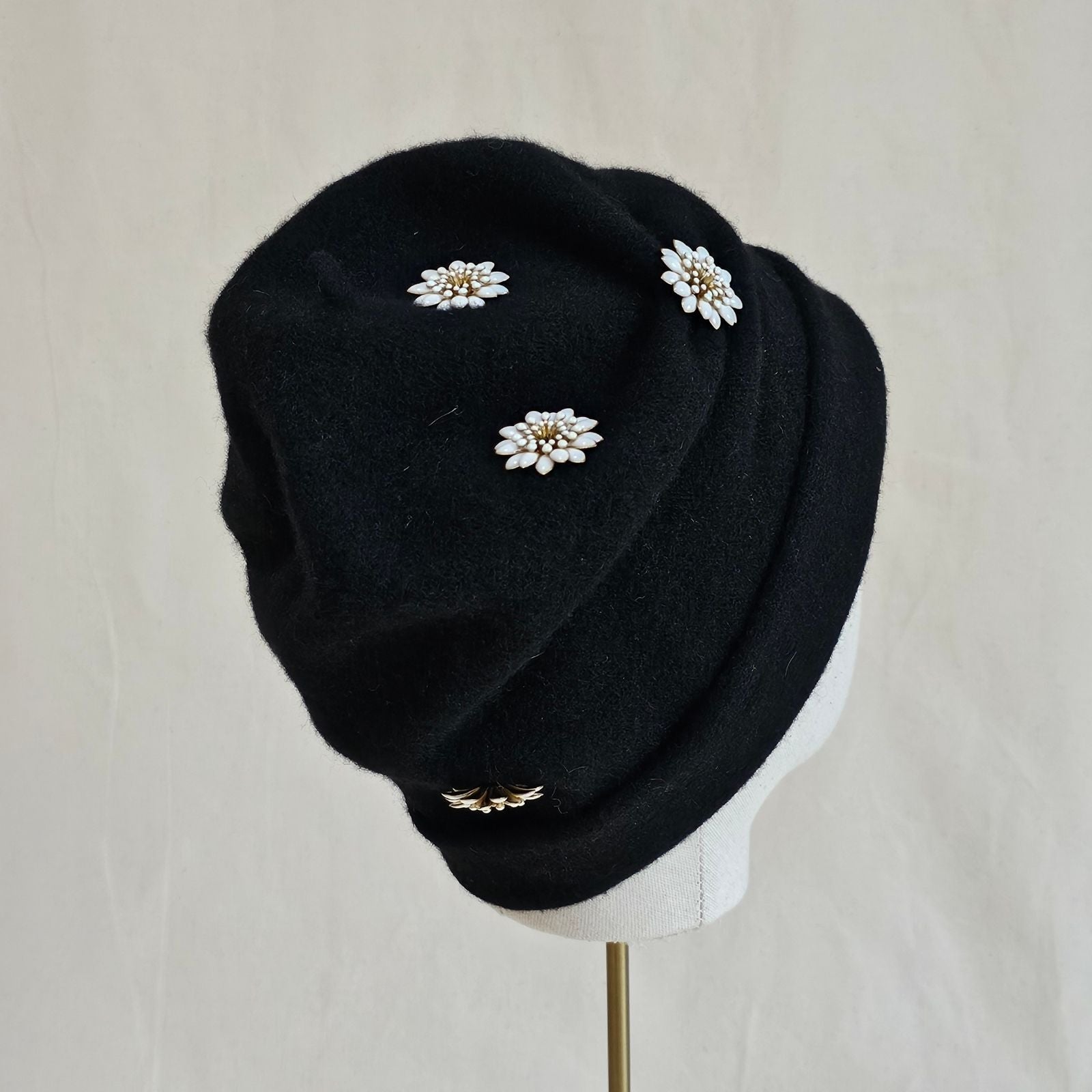 Black wool beanie with beautiful white daisy embellishments, back view.