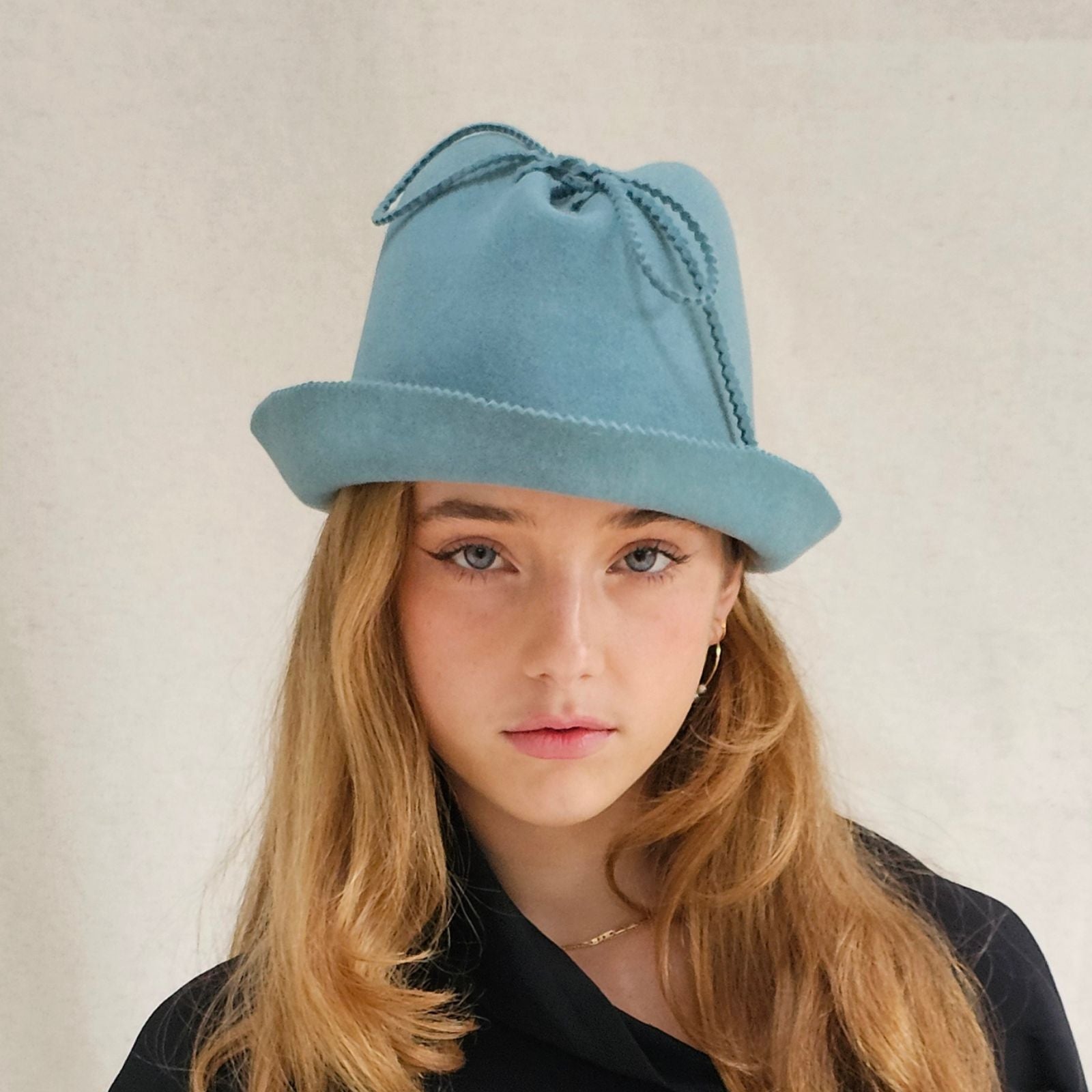 Blue felt trilby with beautiful bow embellishment, front view.