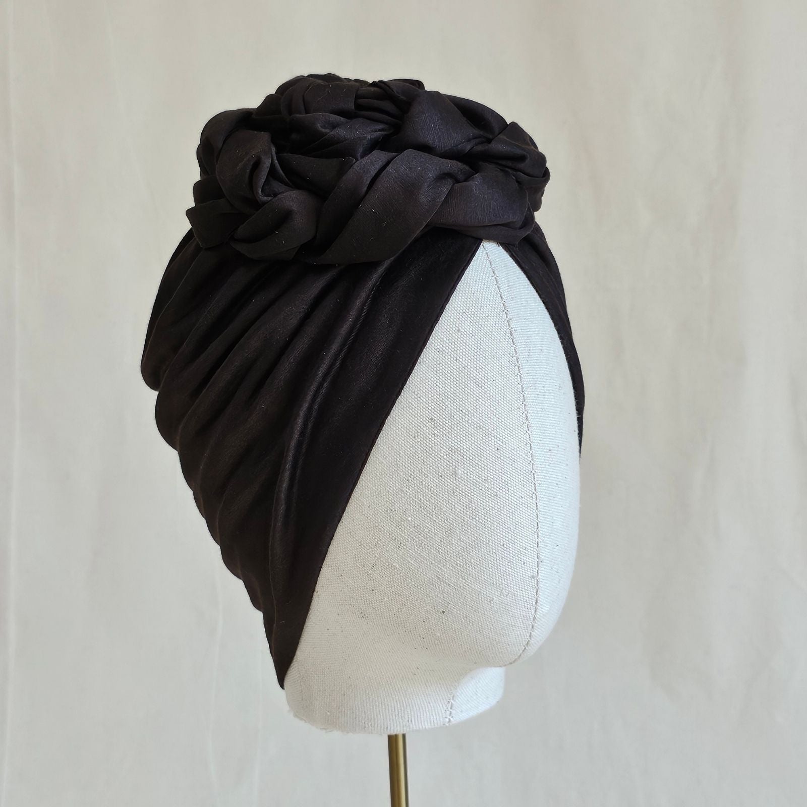 Brown cotton turban loosely gathered into intricate braid design, right view.