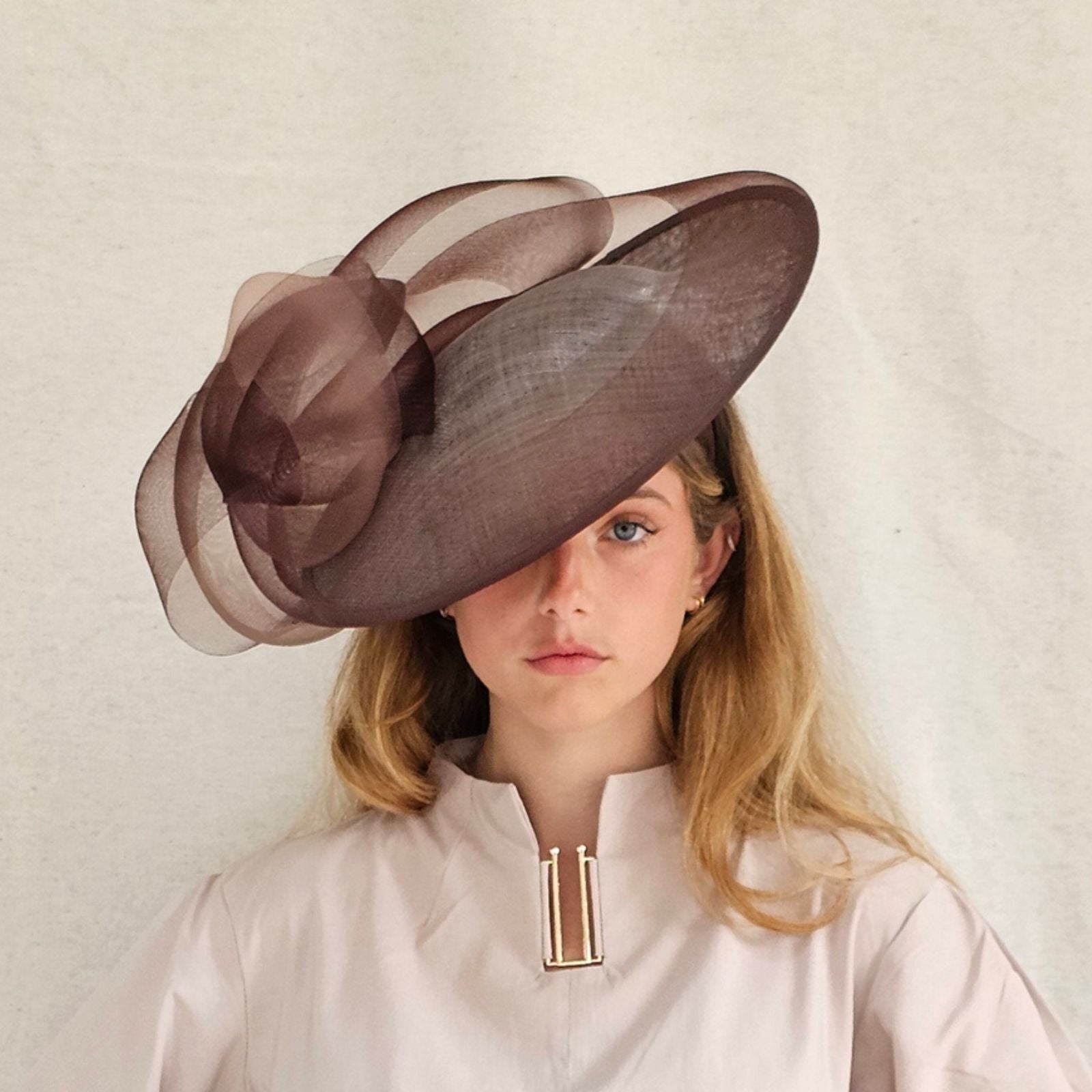 Brown sinamay disc hat with elegant crin bow swirl, front view.