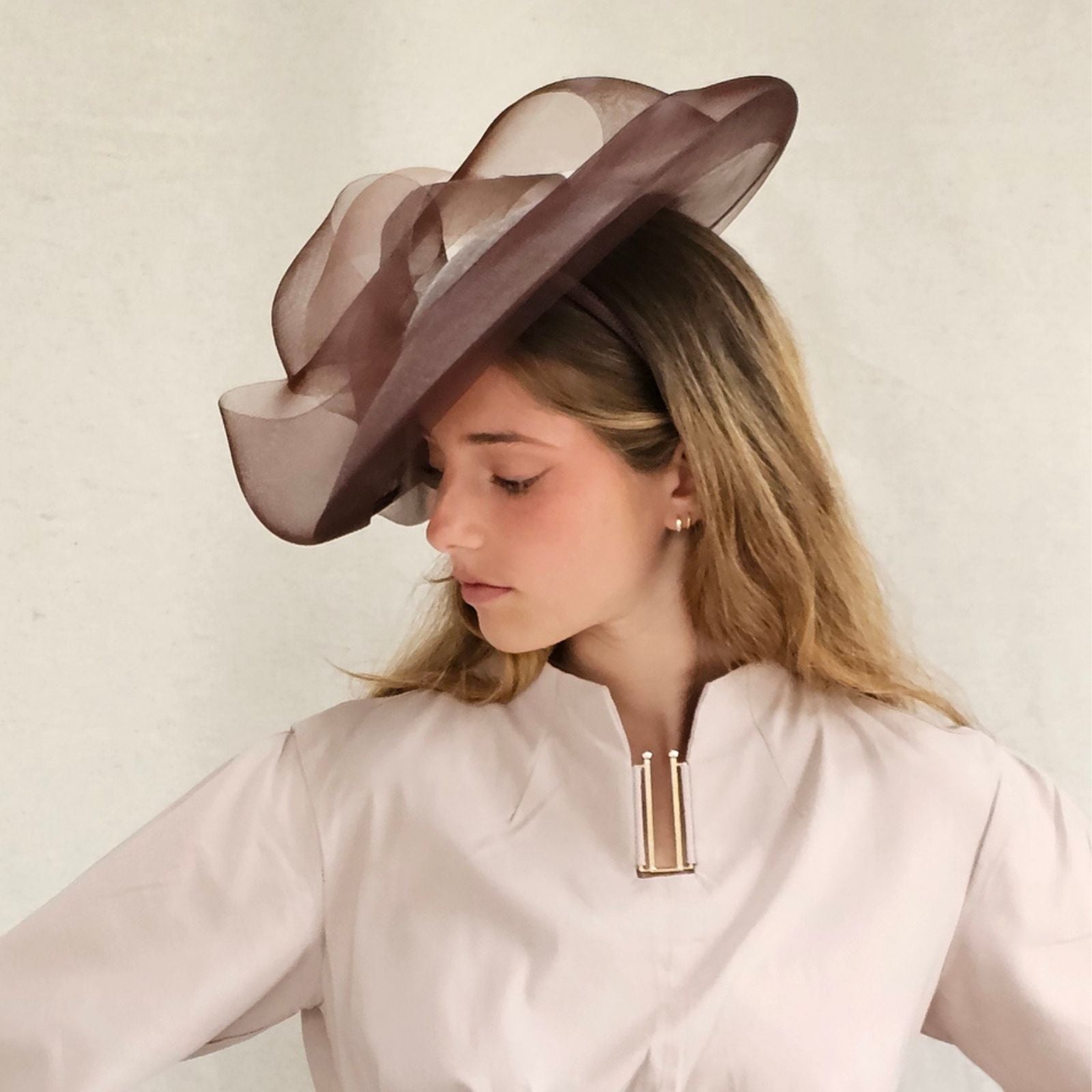 Brown sinamay disc hat with elegant crin bow swirl, left side view.