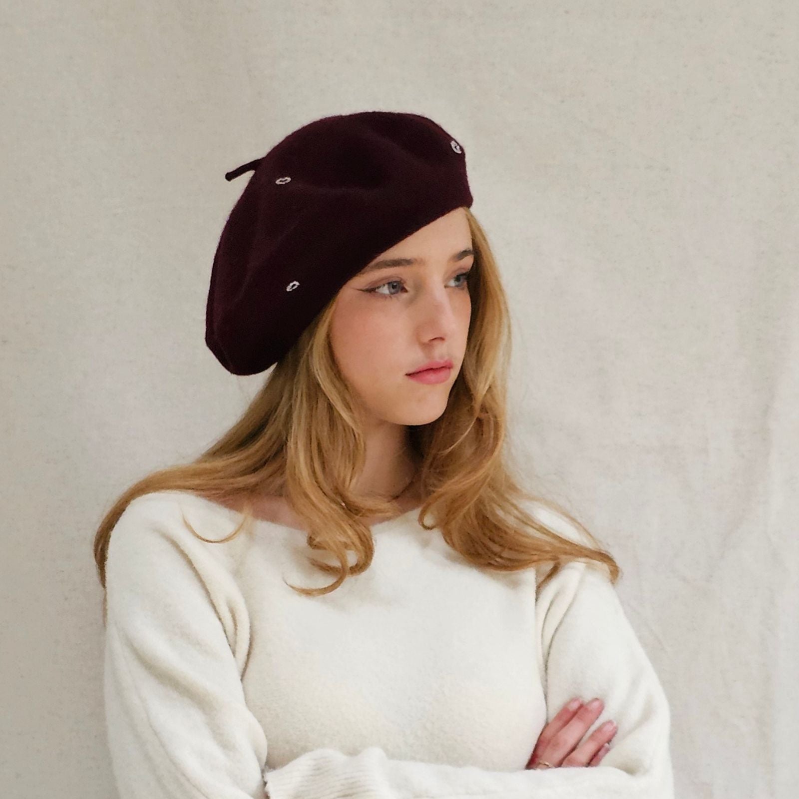 Burgundy wool beret with beautiful silver heart embellishments, side distance view.