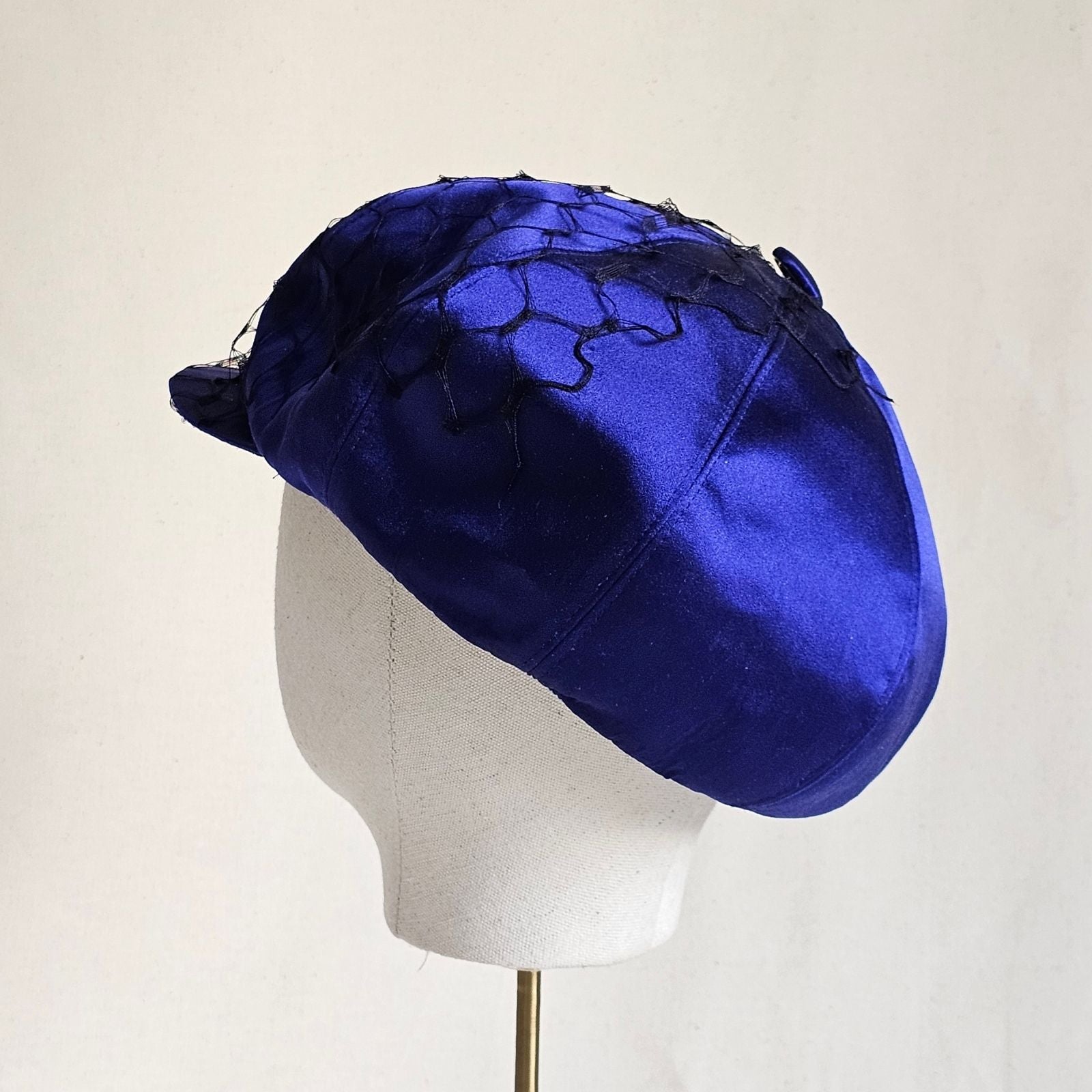 Cobalt silk baker boy hat with black veiling, back view.