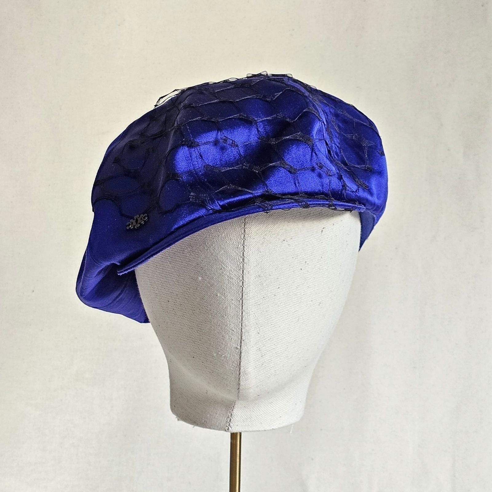 Cobalt silk baker boy hat with black veiling, front view.