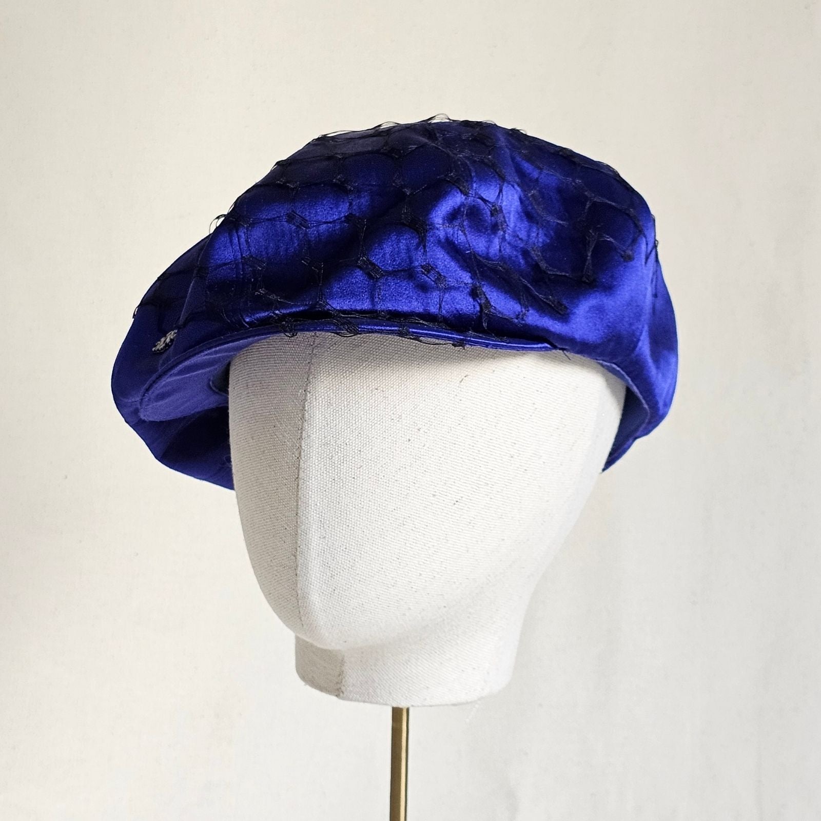 Cobalt silk baker boy hat with black veiling, angle view.
