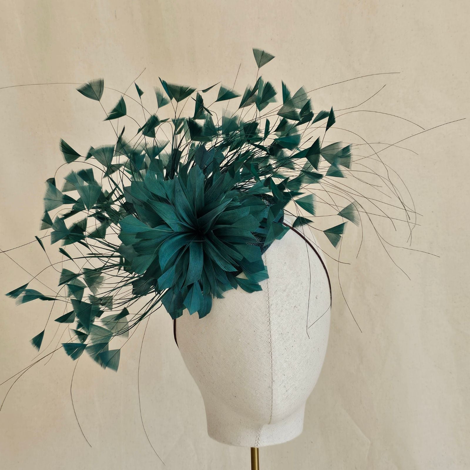 Emerald feather fascinator with feather flower, front view.