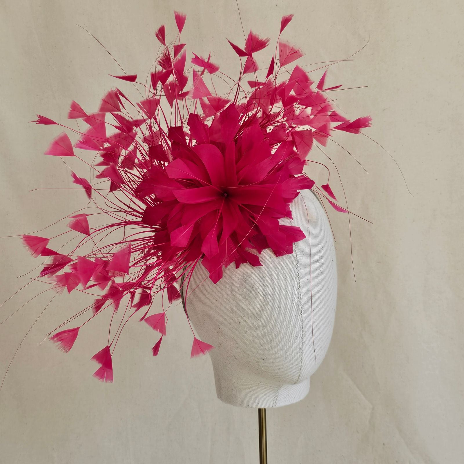 Fuchsia feather fascinator with feather flower, side view.