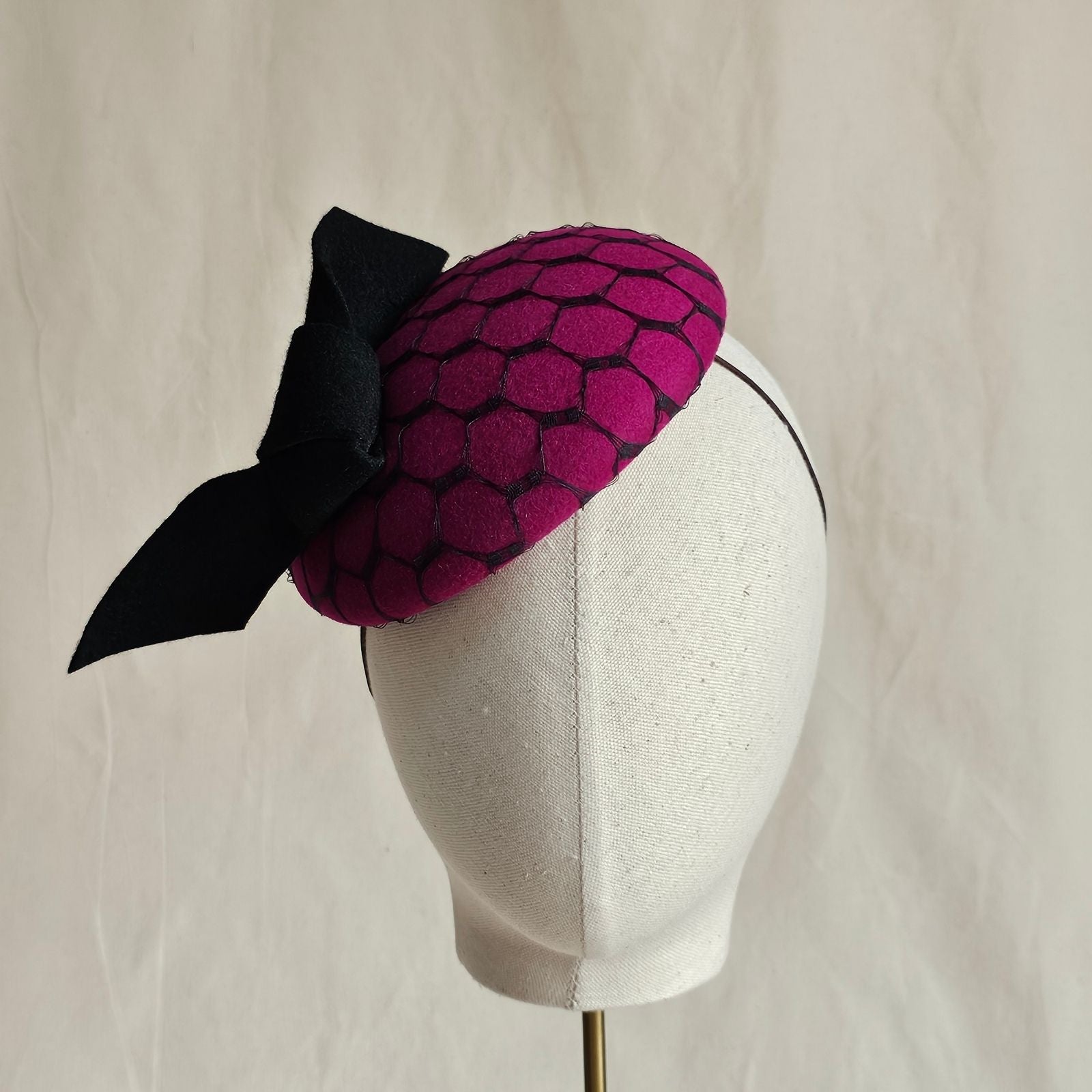 Fuchsia felt beret with black bow and veiling, front view.