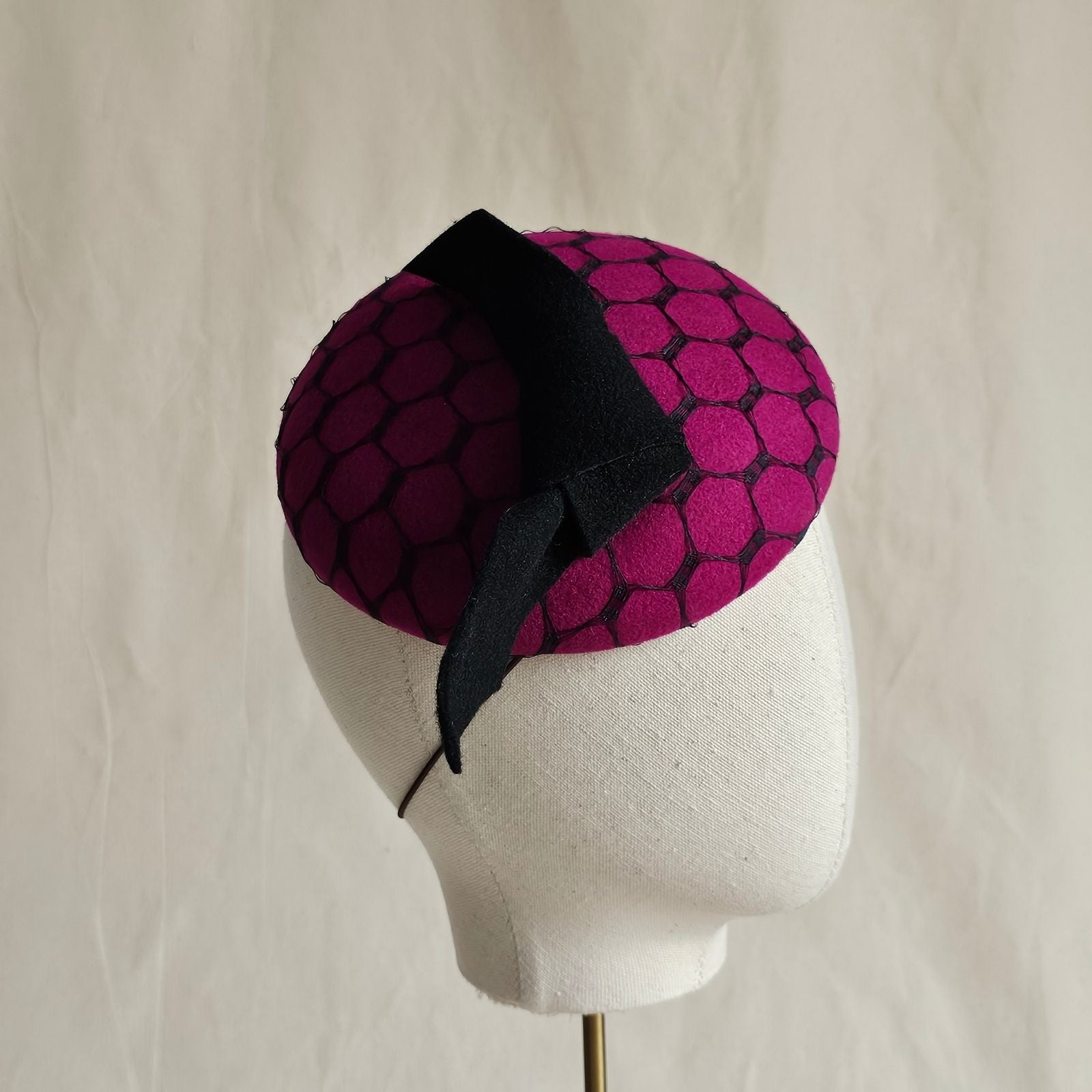 Fuchsia felt beret with black bow and veiling, side view.