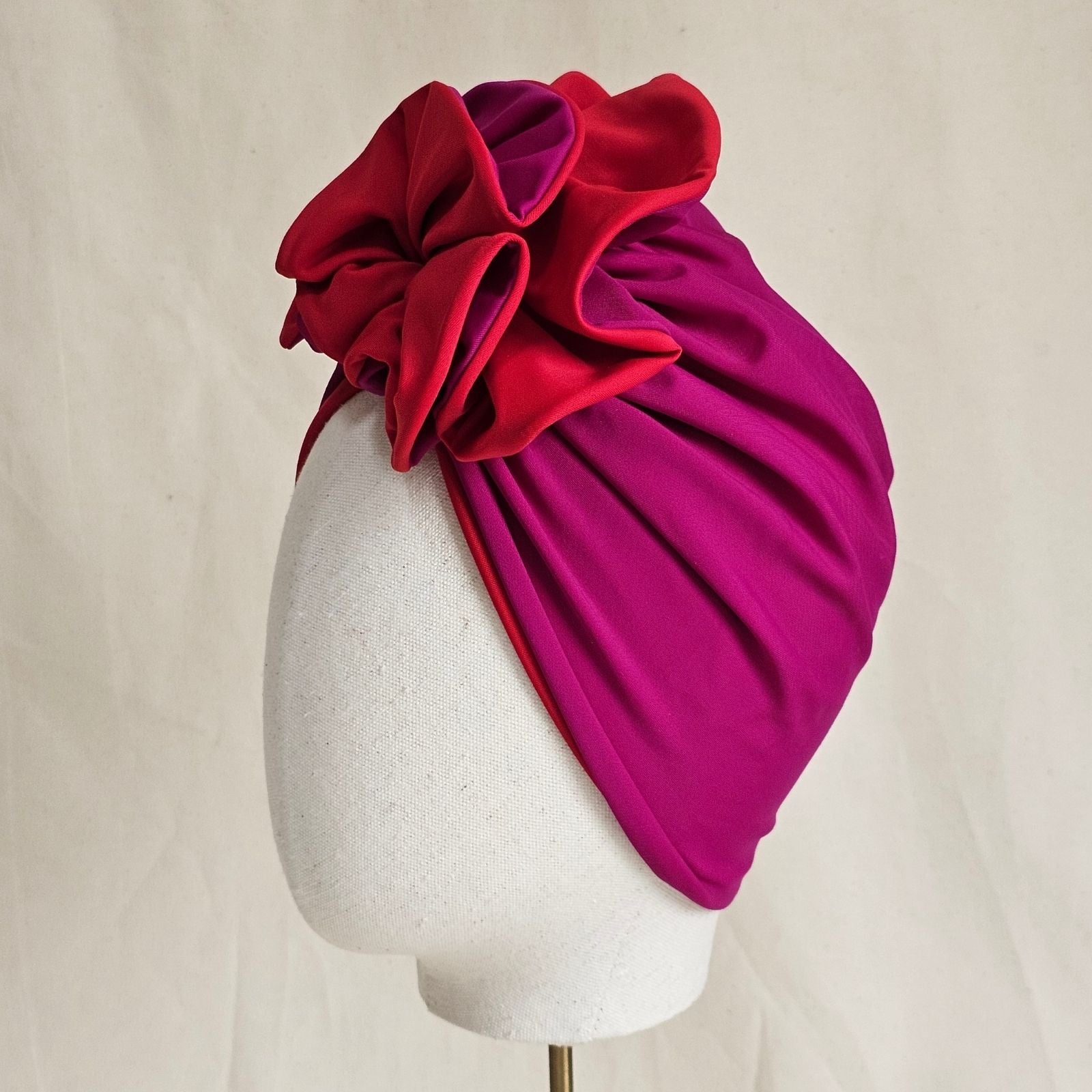 Fuchsia and red swim turban gathered into intricate ruffle, side view.