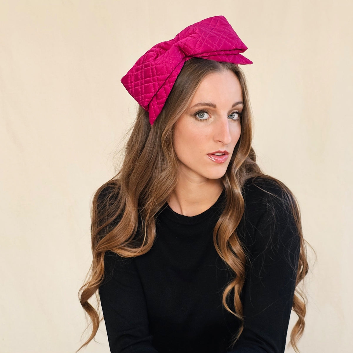 Fuchsia quilted silk bow headband, worn on a model.