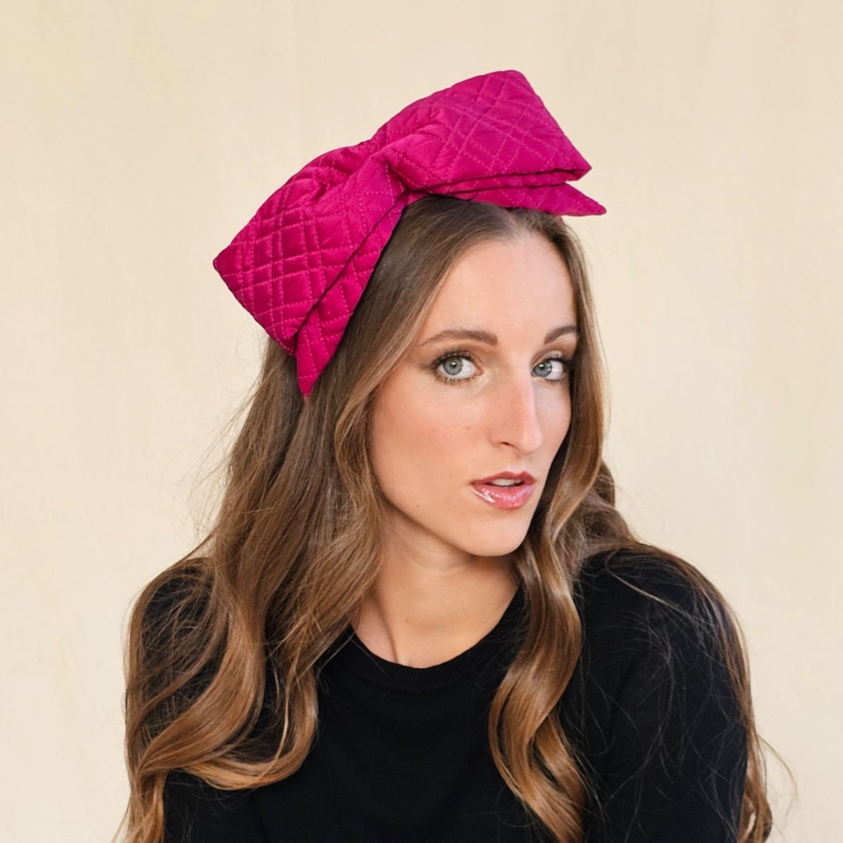 Fuchsia quilted silk bow headband, worn on a model.