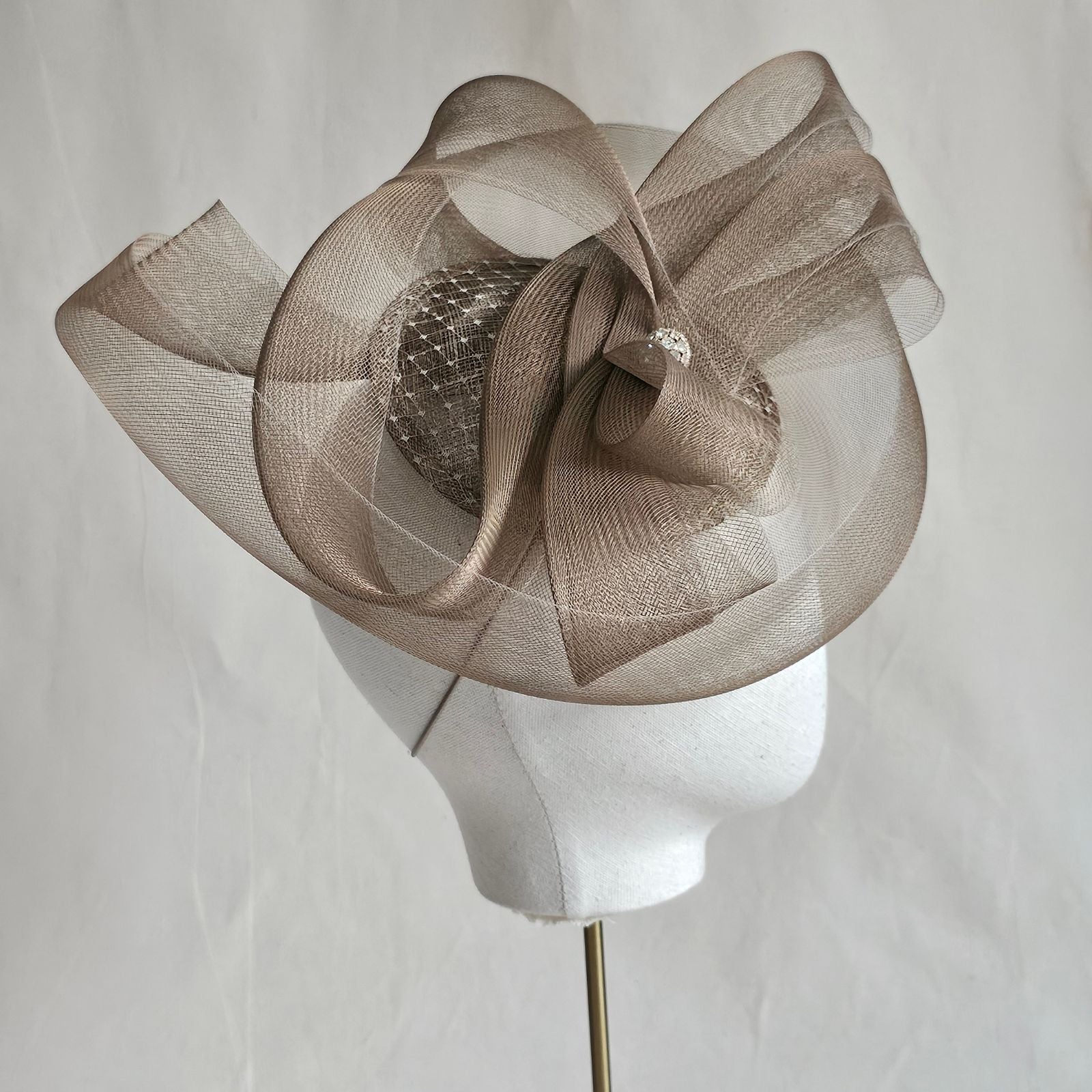 Gold fascinator with elegant crin swirls and crystal diamanté globe embellishment, side view.