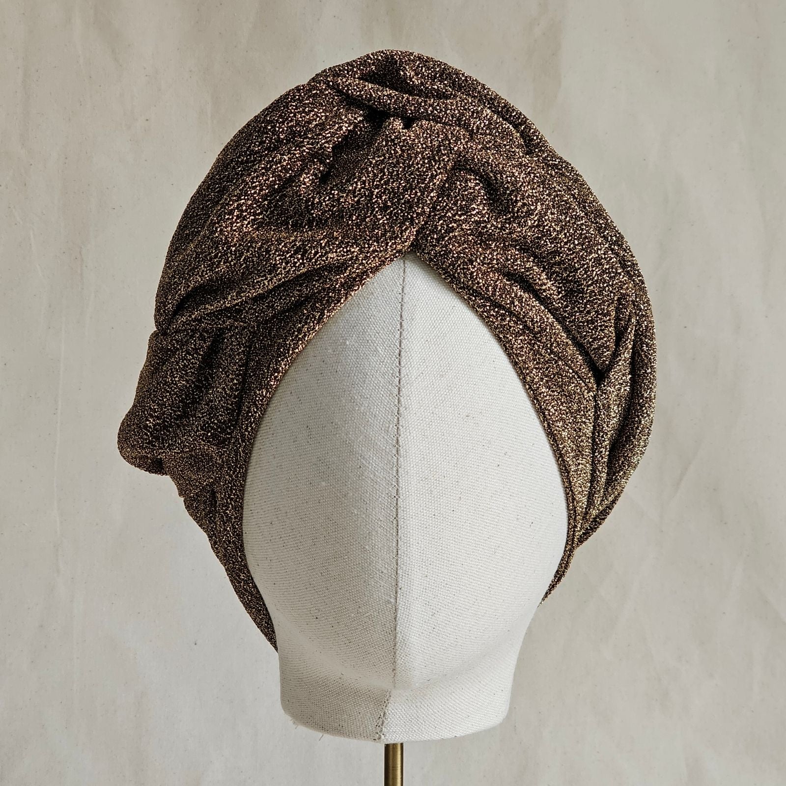 Gold lurex turban with intricate gathers, front view.