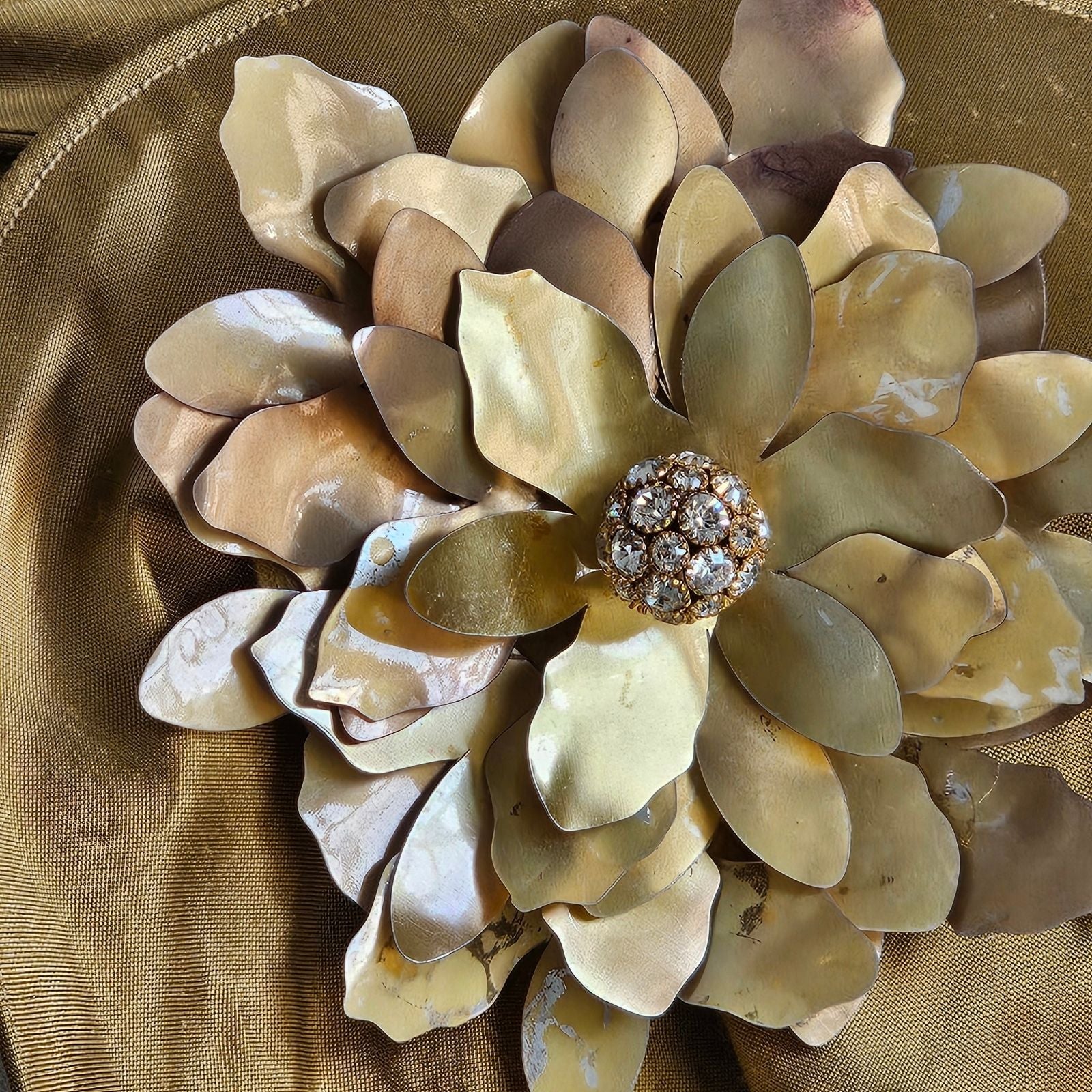 Detail of gold sequin flower brooch with diamanté globe centre.
