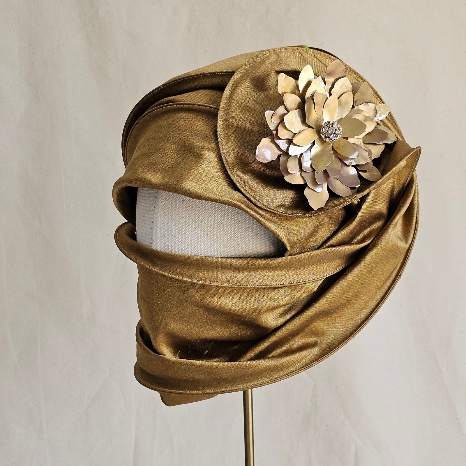 Gold silk scarf turban with diamanté globe flower brooch, side view.