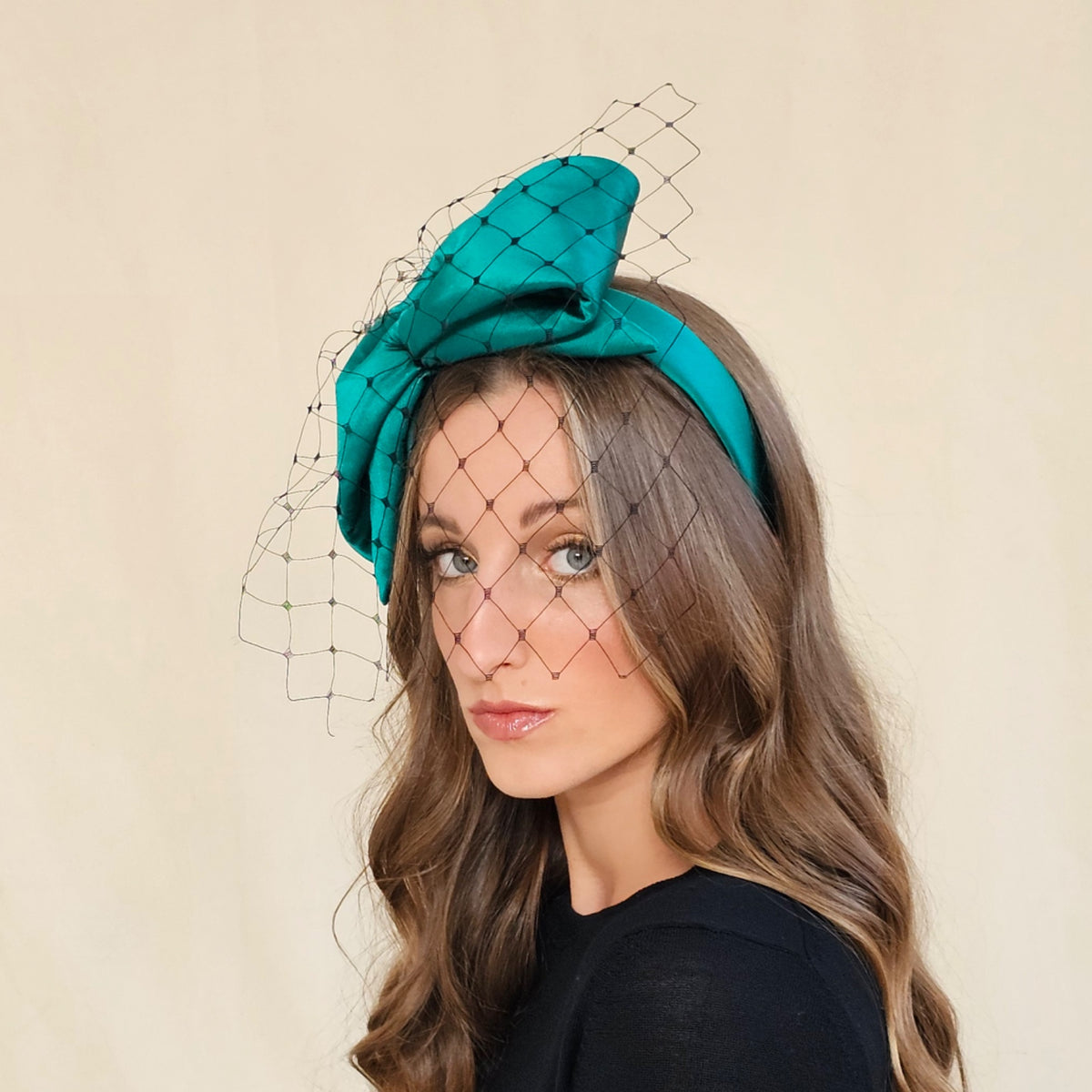 Angled view of emerald silk bow headband showing the padded
bow and black veil.