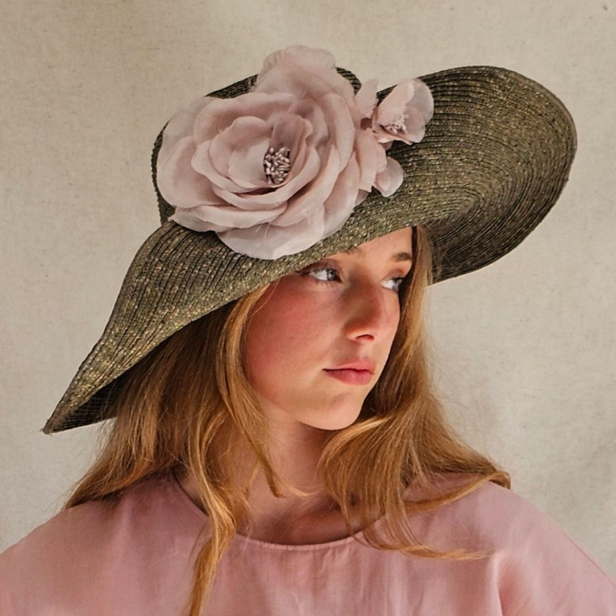 Green straw breton sunhat with beautiful pink flowers, side view.
