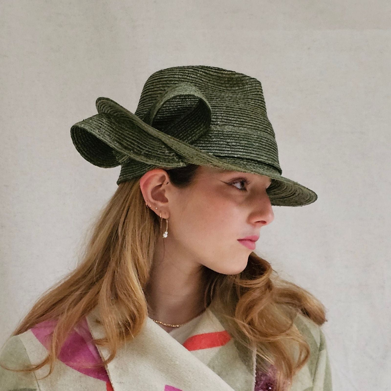Green straw trilby with elegant bow swirl, right view.