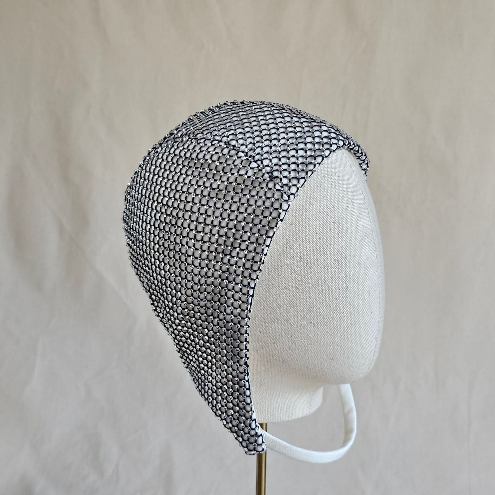 Ivory aviator cap with intricate crystal mesh, right view.