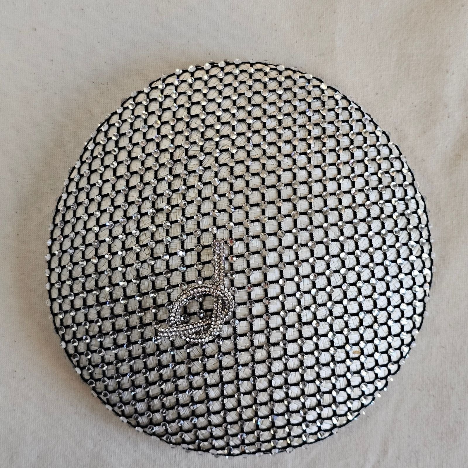 Ivory beret with intricate crystal mesh and beautiful pretzel knot embellishment, top view.