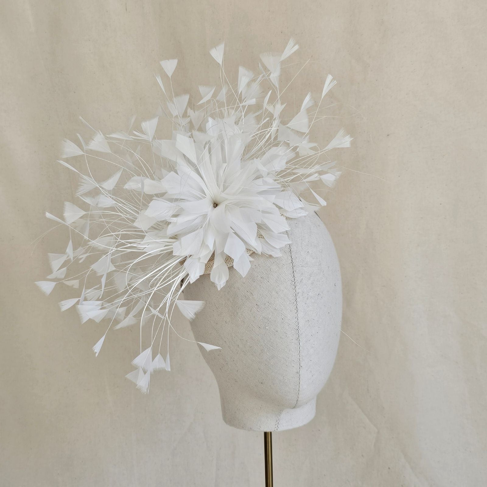 Ivory feather fascinator with feather flower, front view.