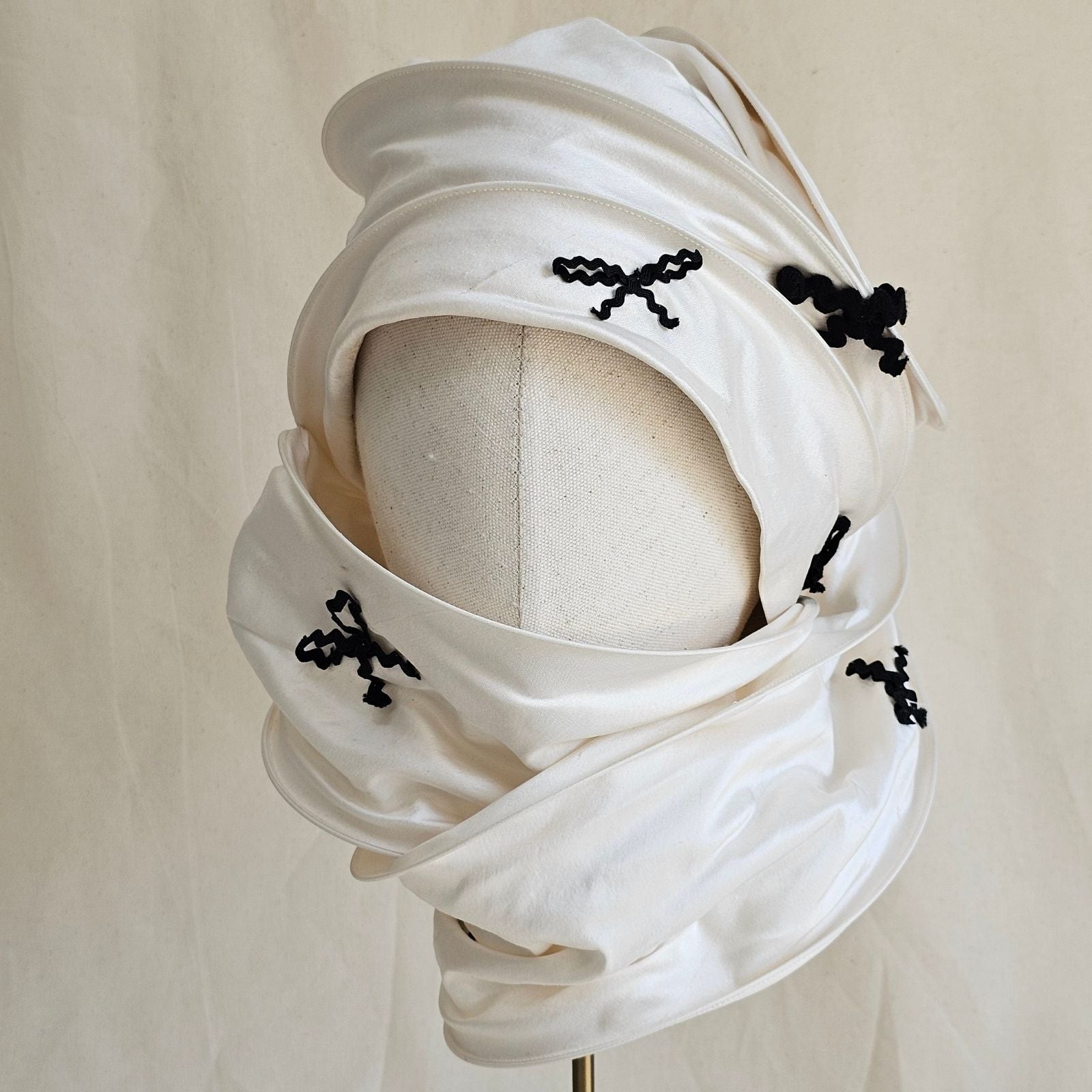 Ivory silk scarf turban with black bow detail, front view.