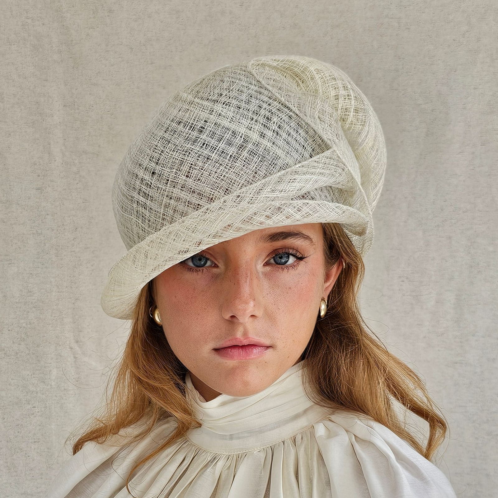 Ivory sinamay sculptural cloche hat, front view.
