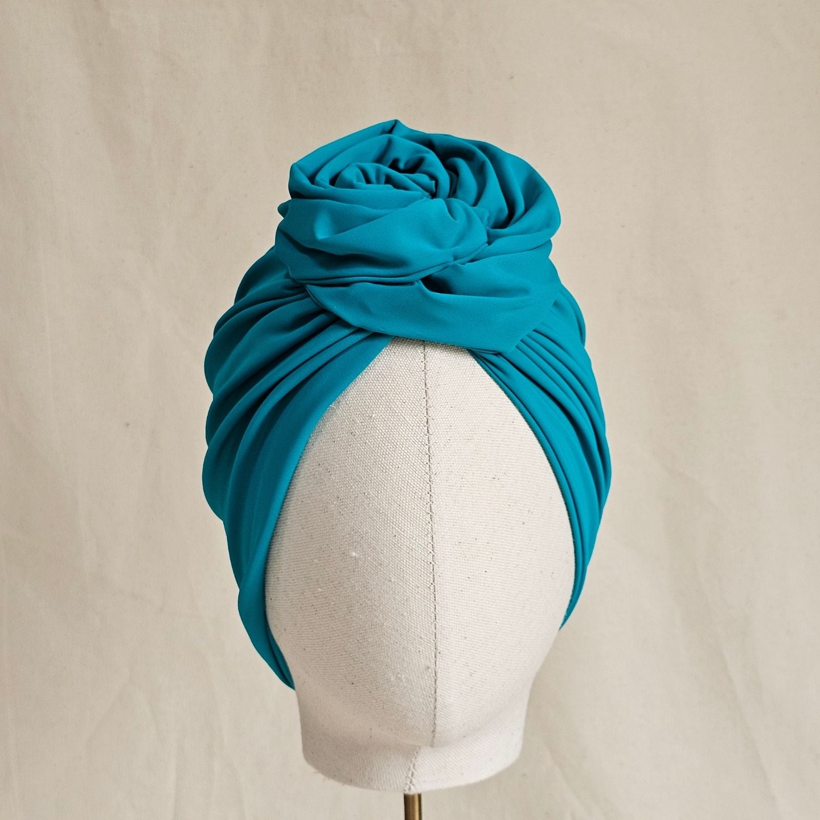 Jade swim turban gathered into sculpted intricate rose knot, front view.