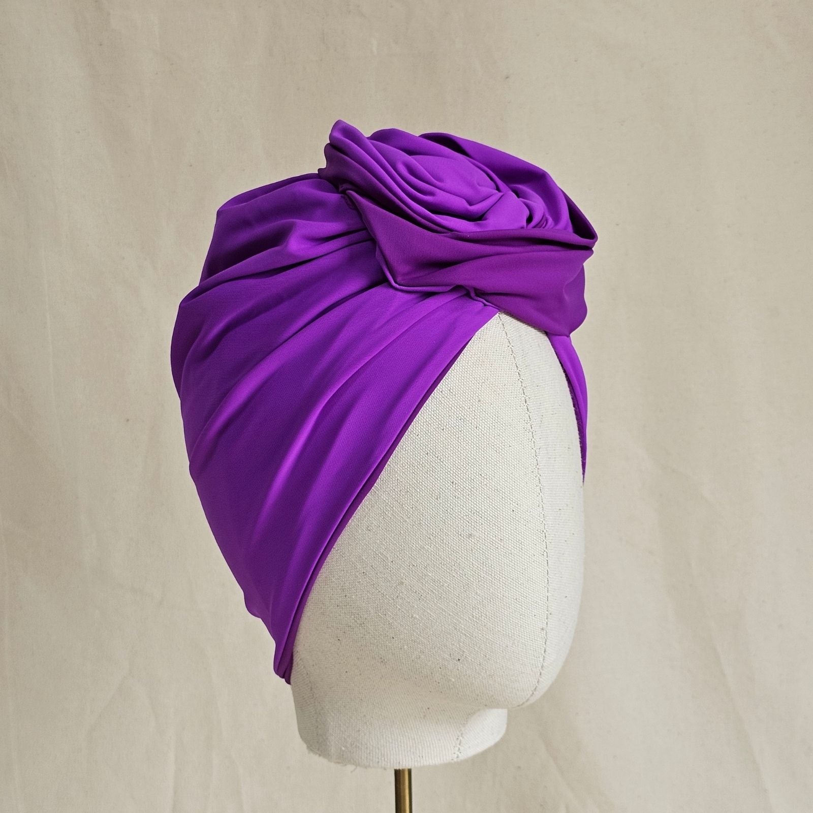 Lilac swim turban gathered into sculpted rose knot, angle view.