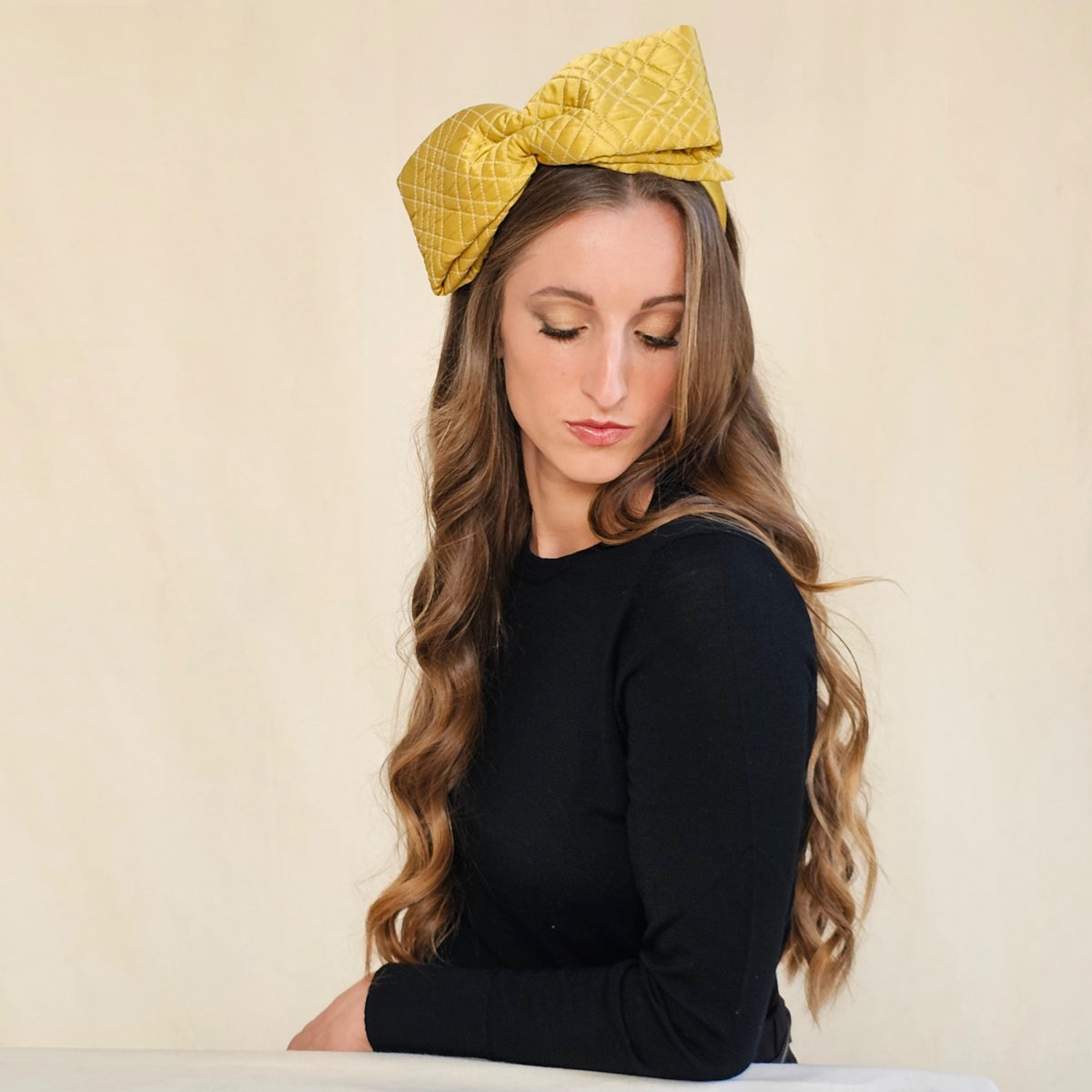 Ochre quilted silk bow headband, worn on a model.