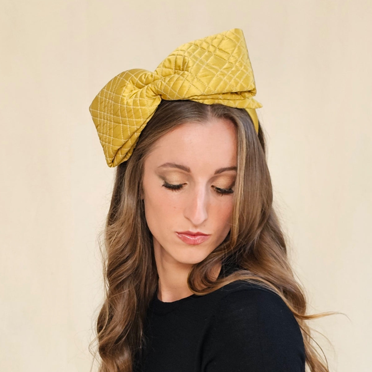 Ochre quilted silk bow headband on a seated model, a closeup showing its
width .