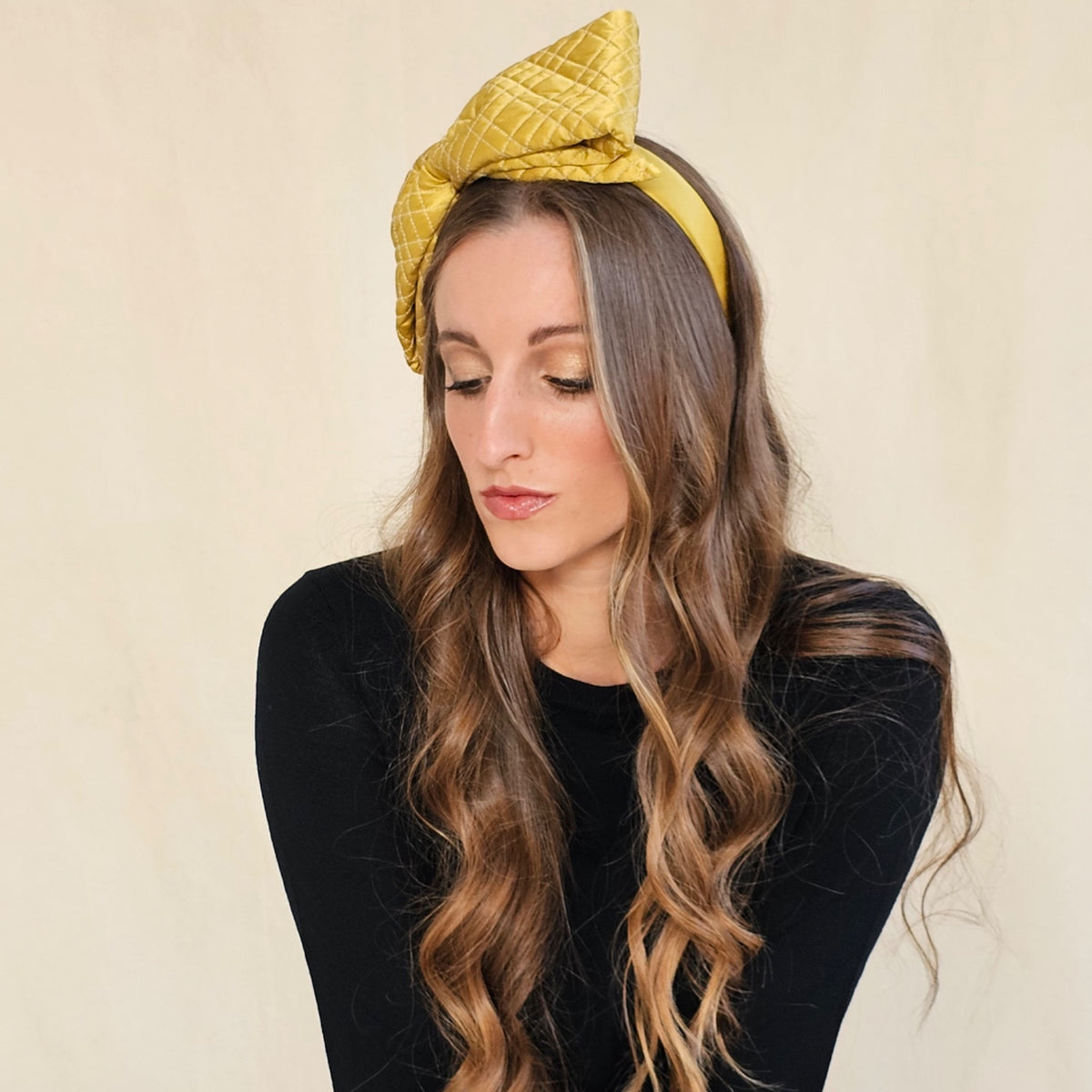 Angled view of ochre silk headband showing the upright quilted
bow.