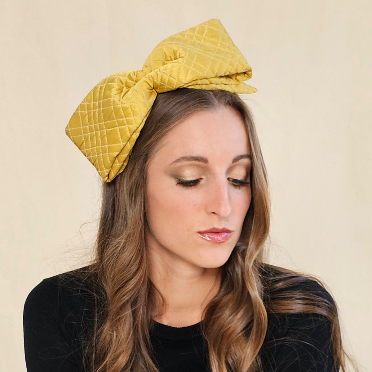Close-up of ochre silk bow headband showing diamond quilting.