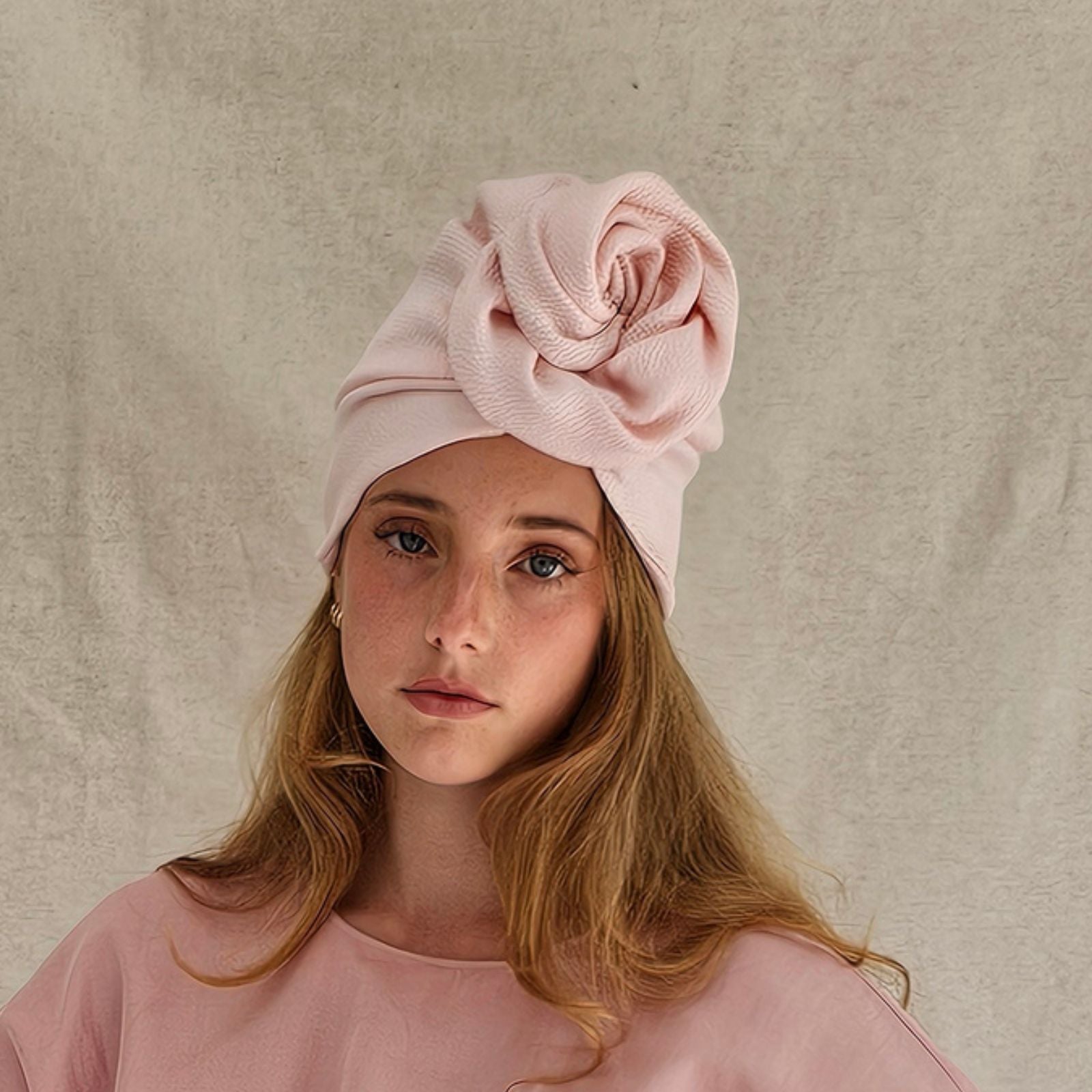 Pink silk turban loosely gathered into beautiful rose design, front view.